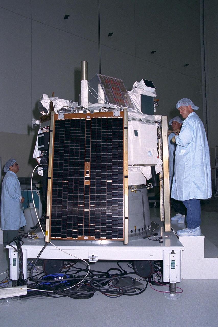 Applied Physics Laboratory engineers and technicians from Johns Hopkins University install solar array panels on the Advanced Composition Explorer (ACE) in KSC’s Spacecraft Assembly and Encapsulation Facility-II. The panel on which they are working is identical to the panel (one of four) seen in the foreground on the ACE spacecraft. Scheduled for launch on a Delta II rocket from Cape Canaveral Air Station on Aug. 25, ACE will study low-energy particles of solar origin and high-energy galactic particles for a better understanding of the formation and evolution of the solar system as well as the astrophysical processes involved. The ACE observatory will be placed into an orbit almost a million miles (1.5 million kilometers) away from the Earth, about 1/100 the distance from the Earth to the Sun. The collecting power of instrumentation aboard ACE is at least 100 times more sensitive than anything previously flown to collect similar data by NASA