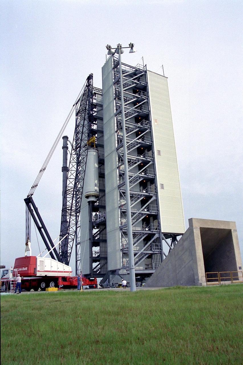 The second stage of the Lockheed Martin Launch Vehicle-2 (LMLV-2) is hoisted into position at Launch Pad 46 at Cape Canaveral Air Station for mating to the rocket’s first stage, which is out of camera view. The LMLV-2 will carry the Lunar Prospector spacecraft, scheduled to launch in October for an 18-month mission that will orbit the Earth’s moon to collect data from the lunar surface. Designed for a low polar orbit investigation of the moon, the Lunar Prospector will map the moon’s surface composition and possible polar ice deposits, measure magnetic and gravity fields, and study lunar outgassing events