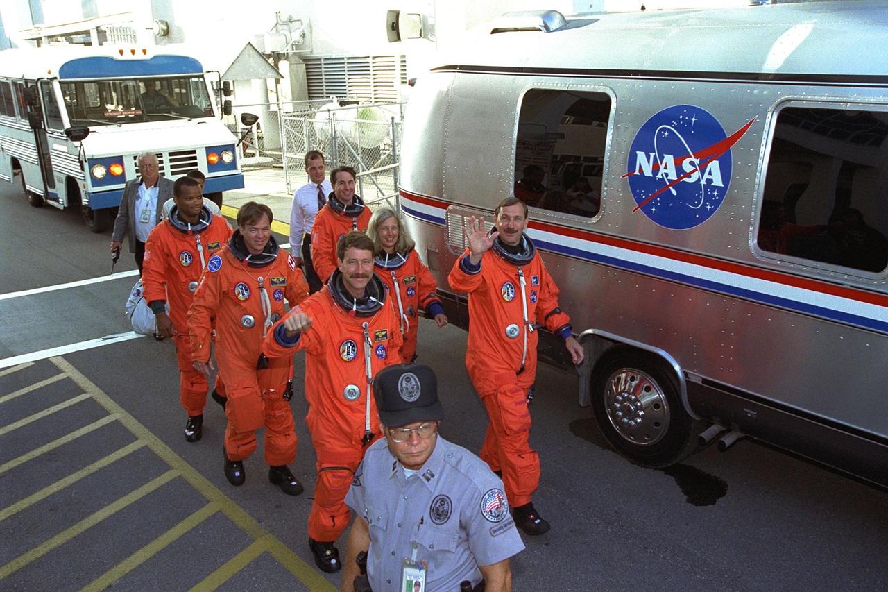 The STS-85 flight crew walks out of the  Operations and Checkout (O&C) Building during Terminal Countdown Demonstration  Test (TCDT) activities for that mission to board the Astrovan for the ride to the  Space Shuttle Discovery on Launch Pad 39A. Waving to the crowd is Commander Curtis  L. Brown, Jr. (right). Directly behind him are Payload Commander N. Jan Davis and  Mission Specialist Stephen K. Robinson. Pilot Kent V. Rominger (to Brown’s right) is  leading the second row, followed by Payload Specialist Bjarni V. Tryggvason and  Mission Specialist Robert L. Curbeam, Jr. The primary payload aboard the Space Shuttle  orbiter Discovery is the Cryogenic Infrared Spectrometers and Telescopes for the  Atmosphere-2 (CRISTA-SPAS-2). Other payloads on the 11-day mission include the  Manipulator Flight Demonstration (MFD), and Technology Applications and Science-1  (TAS-1) and International Extreme Ultraviolet Hitchhiker-2 (IEH-2) experiments