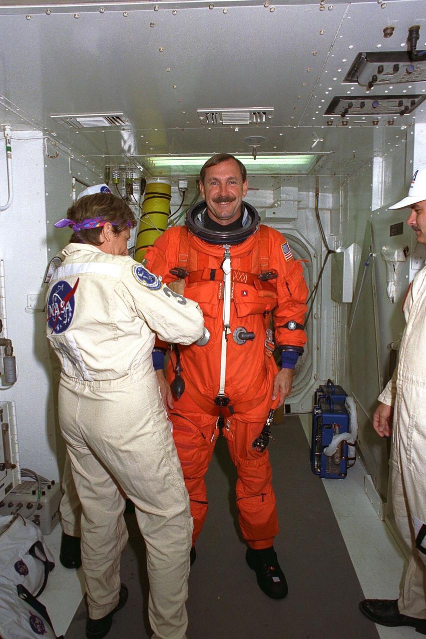 STS-85 Commander Curtis L. Brown, Jr., is  assisted with his ascent/reentry flight suit by a white room crew member as he prepares   to enter the Space Shuttle orbiter Discovery at Launch Pad 39A during Terminal  Countdown Demonstration Test (TCDT) activities for that mission. The primary payload  aboard the Space Shuttle orbiter Discovery is the Cryogenic Infrared Spectrometers and  Telescopes for the Atmosphere-2 (CRISTA-SPAS-2). Other payloads on the 11-day  mission include the Manipulator Flight Demonstration (MFD), and Technology  Applications and Science-1 (TAS-1) and International Extreme Ultraviolet Hitchhiker-2  (IEH-2) experiments