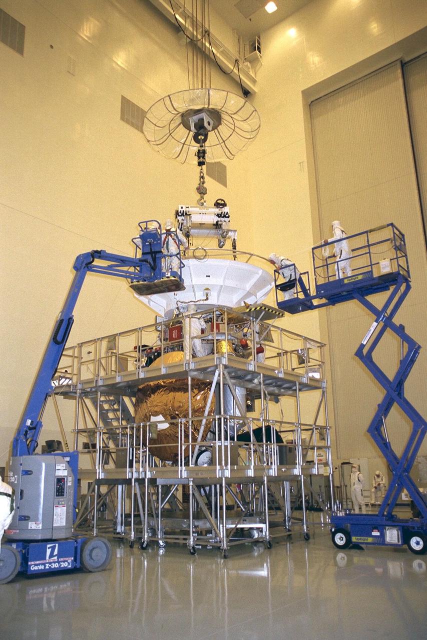 Flight mechanics from NASA’s Jet Propulsion Laboratory (JPL) in Pasadena, Calif., work on the lifting fixture that picks up the Cassini spacecraft in KSC’s Payload Hazardous Servicing Facility. The orbiter alone weighs about 4,750 pounds (2,150 kilograms). At launch, the combined orbiter, Huygens probe, launch vehicle adapter, and propellants will weigh about 12,346 pounds (5,600 kilograms). Scheduled for launch in October, the Cassini mission, a joint US-European four-year orbital surveillance of Saturn's atmosphere and magnetosphere, its rings, and its moons, seeks insight into the origins and evolution of the early solar system. JPL is managing the Cassini project for NASA