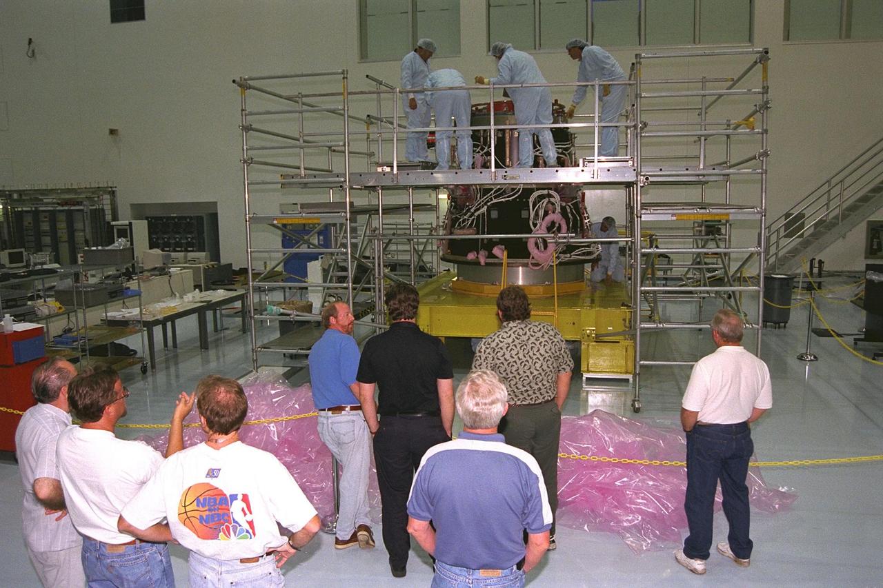 International Space Station (ISS) contractors erect access scaffolding around the Pressurized Mating Adapter-1 (PMA-1) for the ISS in KSC’s Space Station Processing Facility. A PMA is a cone-shaped connector that will be attached to Node 1, the space station’s structural building block, during ground processing. The white flight cables around PMA-1 will assist in connecting the node to the U.S.-financed, Russian-built Functional Cargo Block, a component that supplies early power and propulsion systems for the station. Node 1 with two adapters attached will be the first element of the station to be launched aboard the Space Shuttle Endeavour on STS-88 in July 1998
