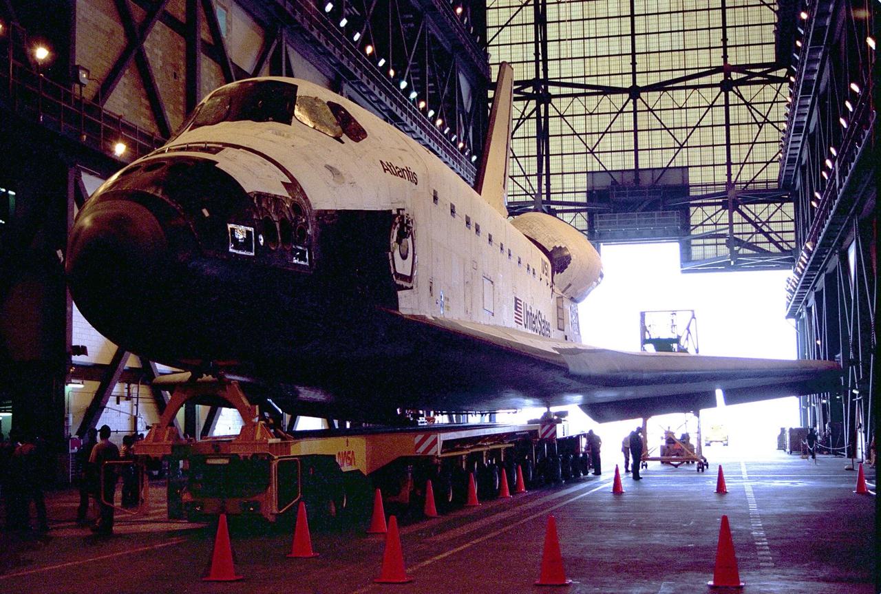 Carried atop an orbiter transporter, the Space Shuttle orbiter Atlantis rolls into the transfer aisle of the Vehicle Assembly Building (VAB) . The "rollover" of the orbiter from the Orbiter Processing Facility to the nearby VAB is one of the prelaunch milestones. Atlantis is being readied for the next mission, STS-86, which is targeted for a September launch. STS-86 will be the seventh of nine planned dockings of the Space Shuttle orbiter with the Russian Space Station Mir