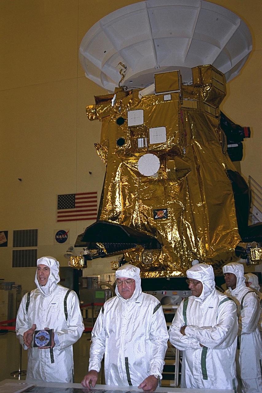 In the Payload Hazardous Servicing Facility (PHSF), Charley Kohlhase, Cassini's science and mission design manager, who oversaw the development of the Digital Video Disk (DVD), discusses it with members of the press. To Kohlhase's left are Richard J. Spehalski, Cassini project manager, and Hamid Hassan, the European Space Agancy Huygens manager. Kohlhase holds the high-tech data disk that will be installed on the Cassini spacecraft. More than 616,400 signatures from 81 countries around the world are on the disk. The Cassini spacecraft is being prepared for launch on Oct. 6, 1997. It will be launched on an Air Force Titan IV/Centaur launch vehicle on an international scientific mission to the planet Saturn. It is destined to arrive at Saturn in July 2004. The Cassini mission is managed for NASA's Office of Space Science, Washington, D.C., by the Jet Propulsion Laboratory, Pasadena, Calif
