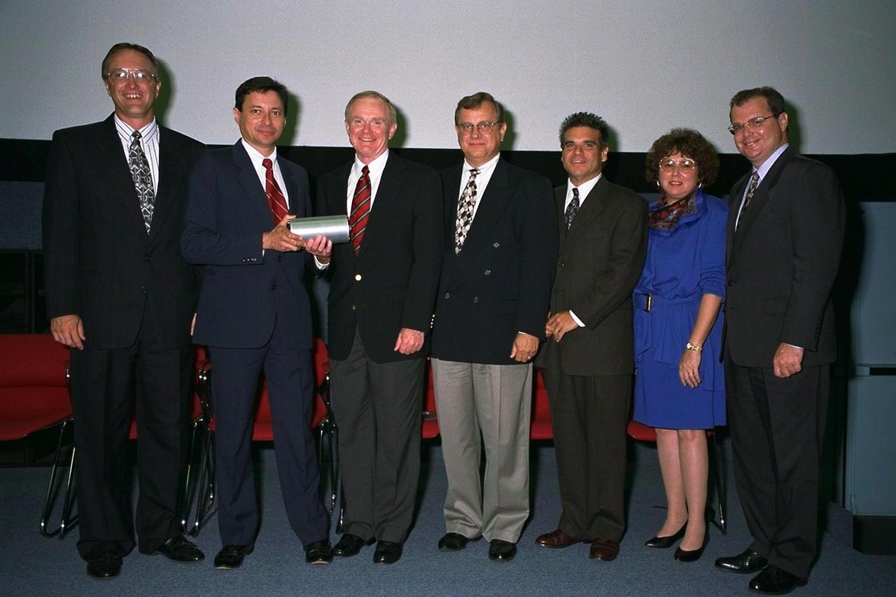 KENNEDY SPACE CENTER, FLA.  -- Following the presentation of the Universal Signal Conditioning Amplifier (USCA), a new piece of technology developed through a National Aeronautics and Space Administration (NASA) partnership with industry, to Kennedy Space Center (KSC) Director Roy Bridges, Jr., key participants in the partnership pose for a group portrait. They are (from left) Bill Larson, NASA; Dr. Pedro Medelius, INET; Roy Bridges, Jr., KSC Director; Ed Gladney and William Saputo, L-3 Communications; Pam Gillespi, representing Congressman Dave Weldon; and Frank Kinney, Technological Research and Development Authority. The USCA is a key component of the codeveloped Automated Data Acquisition System (ADAS) that measures temperature, pressure and vibration at KSC's launch pads. The breakthrough technology is expected to reduce sensor setup and configuration times from hours to seconds. KSC teamed up with Florida's Technological Research and Development Authority and manufacturer L-3 Communications to produce a system that would benefit the aerospace industry and other commercial markets