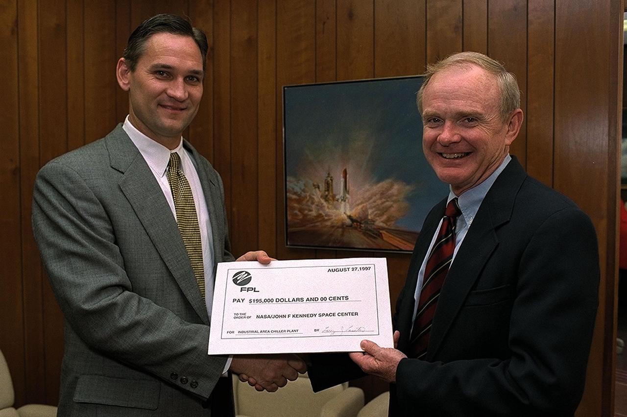 Larry Laseter (left), vice president of Sales and Marketing for the Florida Power & Light (FPL) Company, presents Kennedy Space Center (KSC) Director Roy Bridges Jr., with a rebate check for $195,000, recognizing KSC's commitment to reducing overall energy consumption and costs now and in the future. The energy savings realized by KSC come as a direct result of installing new chilled water systems hardware in the KSC Industrial Area Chiller Plant. KSC has received FPL rebates for its energy-saving efforts since 1993, but this check is the largest single-project rebate to date