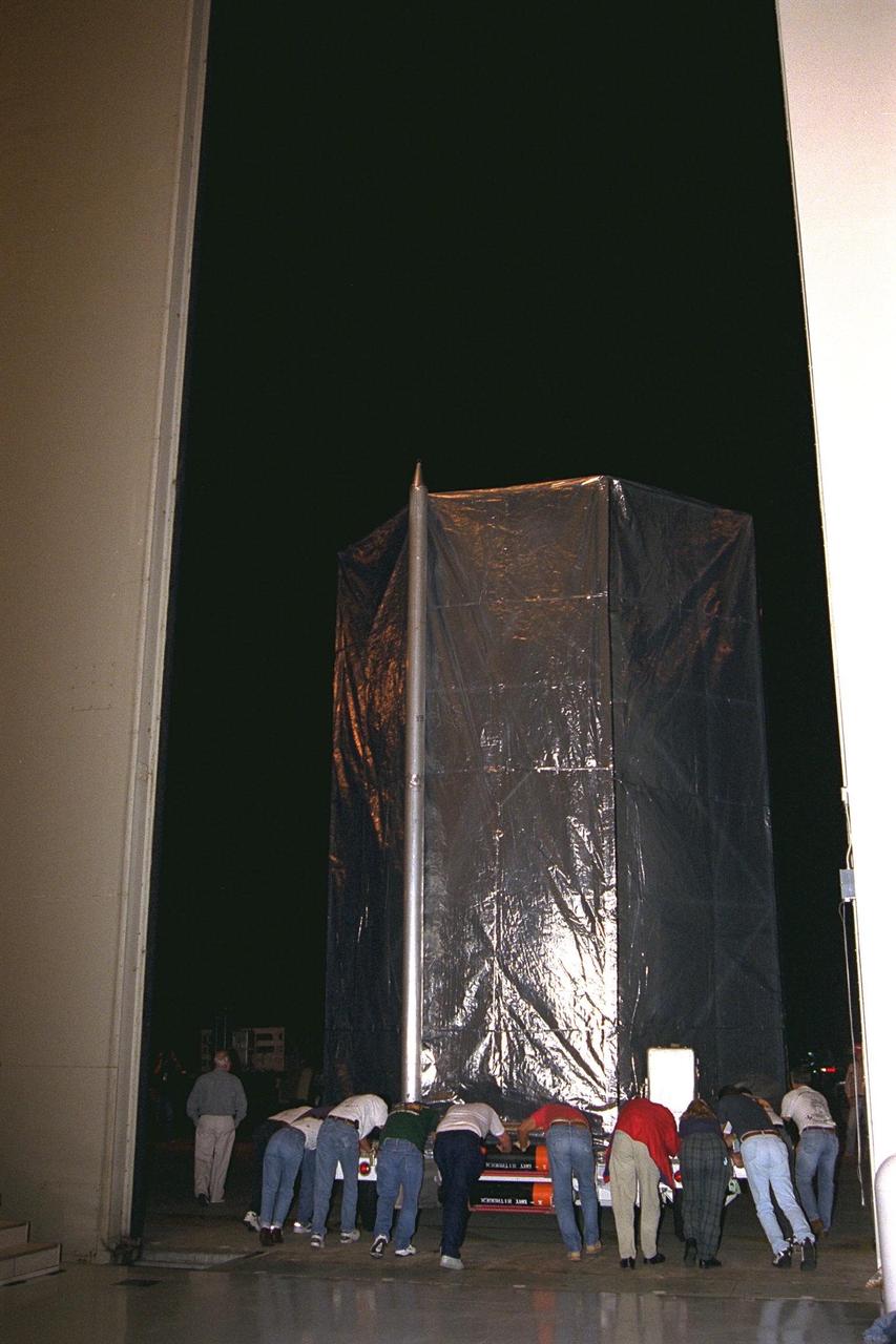 The Cassini spacecraft is rolled out of the Payload Hazardous Servicing Facility (PHSF) at Kennedy Space Center, Fla., shortly before being transported to Complex 40 at Cape Canaveral Air Station (CCAS) where it will be lifted to the top of its Titan IV/Centaur launch vehicle. Cassini is an international mission conducted by the National Aeronautics and Space Administration (NASA), the European Space Agency (ESA), and the Italian Space Agency (ASI). The two-story-tall spacecraft, scheduled for launch on Oct. 6, is destined to arrive at Saturn in July 2004, where it will orbit and study Saturn, its rings, moons and magnetic environment in detail over a four-year period. The Cassini mission is managed for NASA's Office of Space Science by the Jet Propulsion Laboratory, a division of the California Institute of Technology