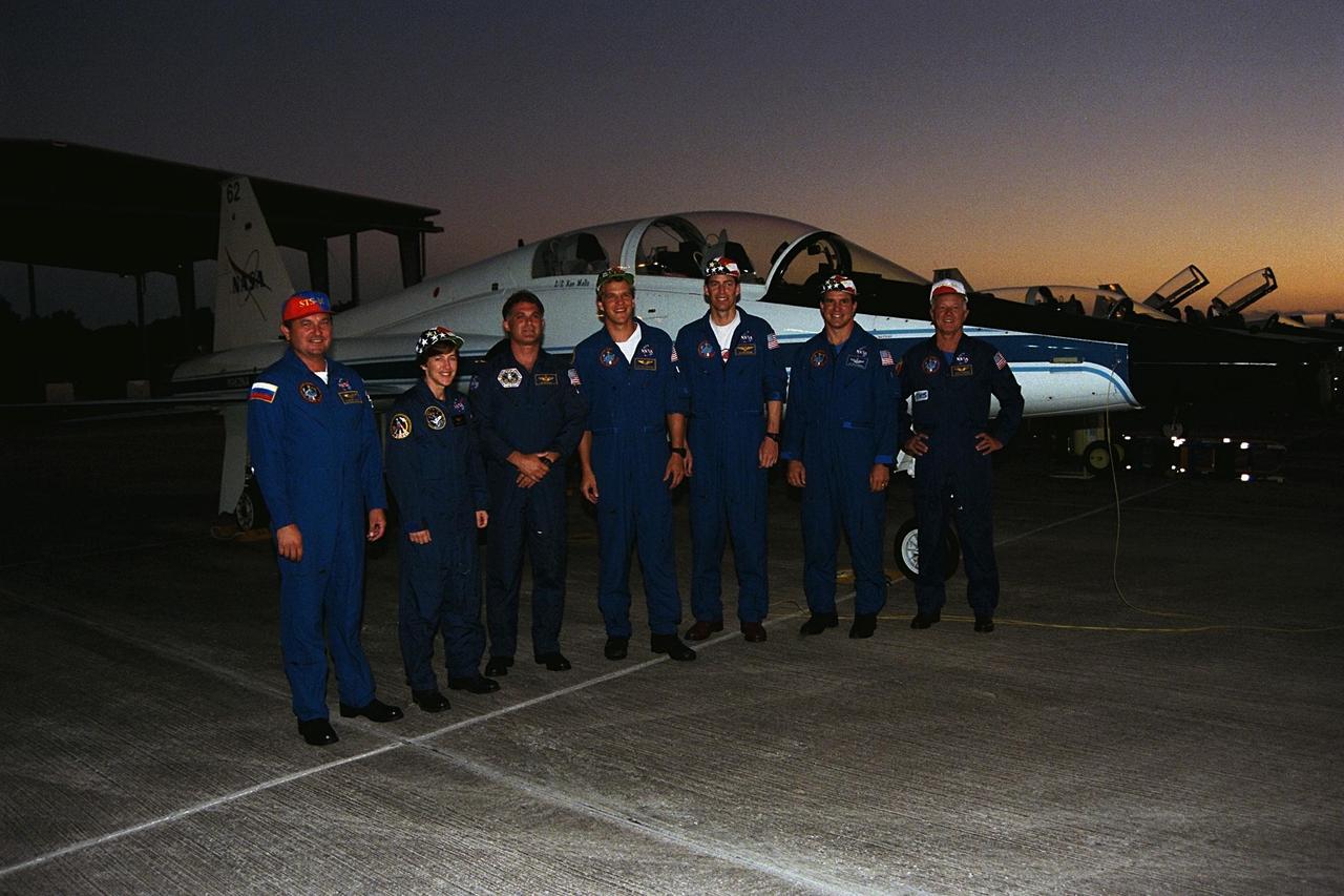 STS-86 crew members pose for a photograph after arrival at KSC’s Shuttle Landing Facility for the Terminal Countdown Demonstration Test (TCDT), a dress rehearsal for launch. From left, are Mission Specialists Vladimir Georgievich Titov of the Russian Space Agency, Wendy B. Lawrence, David A. Wolf and Scott Parazynski; Commander James D. Wetherbee; Pilot Michael J. Bloomfield; and Mission Specialist Jean-Loup J.M. Chretien of the French Space Agency, CNES. STS-86 will be the seventh docking of the Space Shuttle with the Russian Space Station Mir. Wolf will transfer to the Mir for a long-duration stay, replacing Mir 24 crew member C. Michael Foale, who will return to Earth with the rest of the STS-86 crew. The mission is targeted for a Sept. 25 launch aboard the Space Shuttle Atlantis