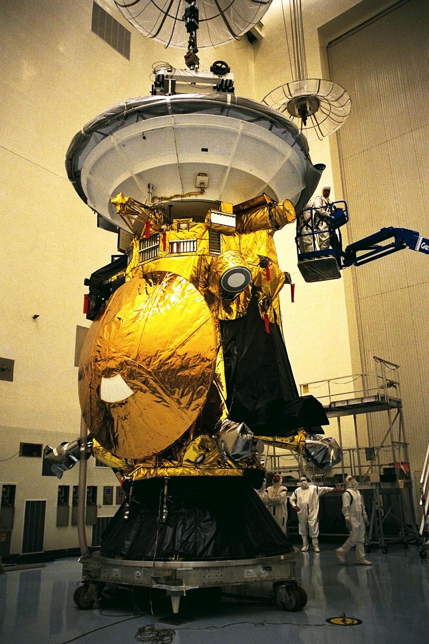 Workers in the Payload Hazardous Servicing Facility (PHSF) finish the removal of a protective cover from the Cassini spacecraft with its attached Huygens probe. Damage to thermal insulation was discovered inside Huygens from an abnormally high flow of conditioned air. Further internal inspection, insulation repair and a cleaning of the probe are now required. Mission managers are targeting a mid-October launch date after Cassini returns to the pad and is once again placed atop its Titan IVB expendable launch vehicle at Launch Pad 40 at Cape Canaveral Air Station. Cassini will explore the Saturnian system, including the planet’s rings, while the Huygens probe will explore the moon Titan