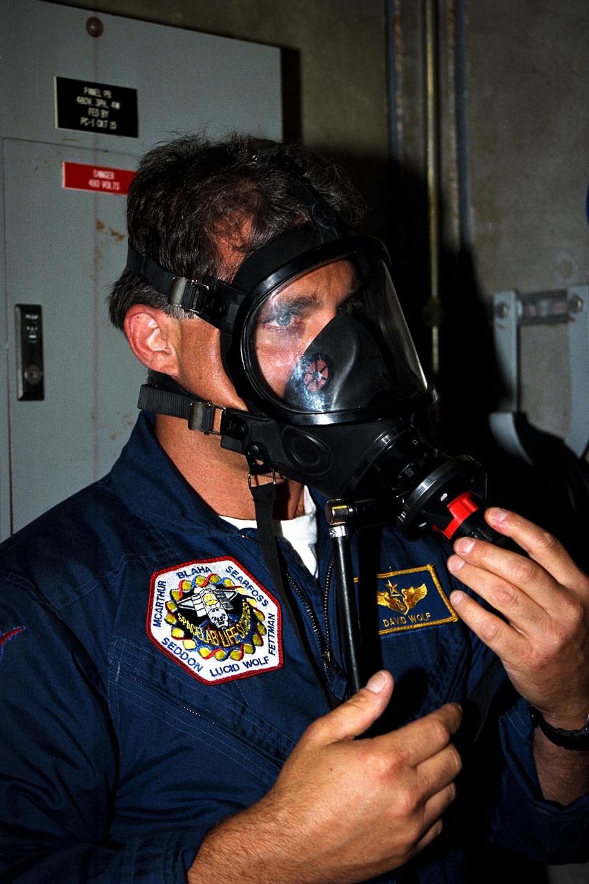 STS-86 Mission Specialist David A. Wolf dons a gas mask as part of training exercises during the Terminal Countdown Demonstration Test (TCDT), a dress rehearsal for launch. Wolf is wearing the patch from his first and only mission to date, STS-58 in 1993. STS-86 will be the seventh docking of the Space Shuttle with the Russian Space Station Mir. During the docking, Wolf will transfer to the orbiting Russian station and become a member of the Mir 24 crew, replacing U.S. astronaut C. Michael Foale, who has been on the Mir since the last docking mission, STS-84, in May. Launch of Mission STS-86 aboard the Space Shuttle Atlantis is targeted for Sept. 25