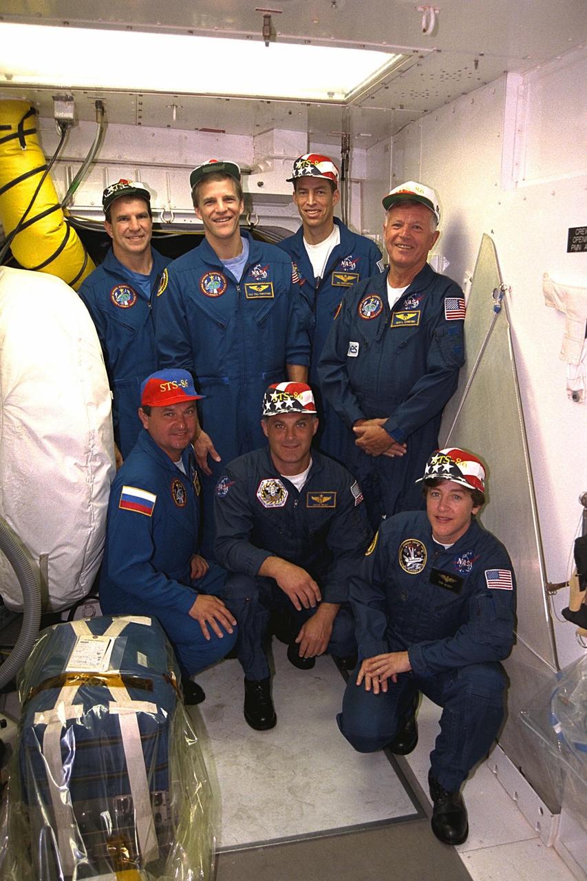 STS-86 crew members pose for a group photograph outside the hatch to the crew cabin of the Space Shuttle Atlantis at Launch Pad 39A. Kneeling in front, from left, are Mission Specialists Vladimir Georgievich Titov of the Russian Space Agency, David A. Wolf and Wendy B. Lawrence. Standing, from left, are Pilot Michael J. Bloomfield, Mission Specialist Scott E. Parazynski, Commander James D. Wetherbee, and Mission Specialist Jean-Loup J.M. Chretien of the French Space Agency, CNES. STS-86 will be the seventh docking of the Space Shuttle with the Russian Space Station Mir. During the docking, Wolf will transfer to the orbiting Russian station and become a member of the Mir 24 crew, replacing U.S. astronaut C. Michael Foale, who has been on the Mir since the last docking mission, STS-84, in May. Launch of Mission STS-86 aboard the Space Shuttle Atlantis is targeted for Sept. 25