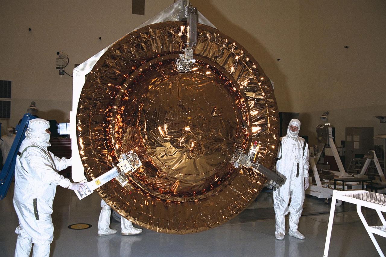 Jet Propulsion Laboratory (JPL) workers remove the Huygens probe from the Cassini spacecraft in the Payload Hazardous Servicing Facility (PHSF) at KSC. The spacecraft was returned to the PHSF after damage to thermal insulation was discovered inside Huygens from an abnormally high flow of conditioned air. Further internal inspection, insulation repair and a cleaning of the probe are now required. Mission managers are targeting a mid-October launch date after Cassini returns to the pad and is once again placed atop its Titan IVB expendable launch vehicle at Launch Pad 40 at Cape Canaveral Air Station