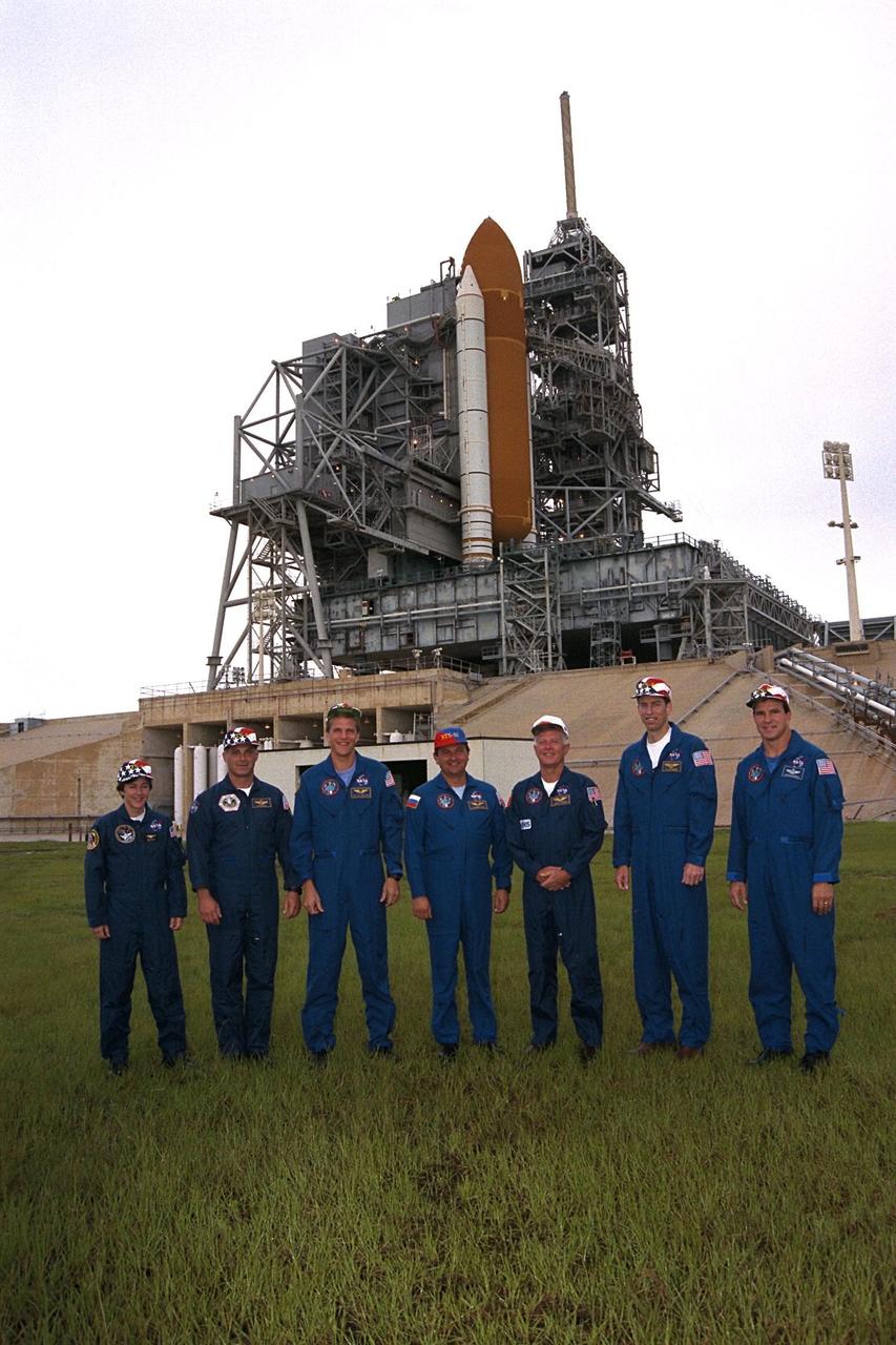KENNEDY SPACE CENTER, Fla. -- With the Space Shuttle Atlantis behind them, the STS-86 crew poses for a photograph at Launch Pad 39A. The seven crew members are at KSC to participate in Terminal Countdown Demonstration Test (TCDT) activities. From left are Mission Specialists Wendy B. Lawrence, David A. Wolf, Scott E. Parazynski, Vladimir Georgievich Titov of the Russian Space Agency, Jean-Loup J.M. Chretien of the French Space Agency, CNES; Commander James D. Wetherbee; and Pilot Michael J. Bloomfield. STS-86 will be the seventh docking of the Space Shuttle with the Russian Space Station Mir. After docking, Wolf will transfer to the Mir 24 crew, replacing astronaut C. Michael Foale, who arrived there during the last docking mission, STS-84, in May. Launch is targeted for Sept. 25