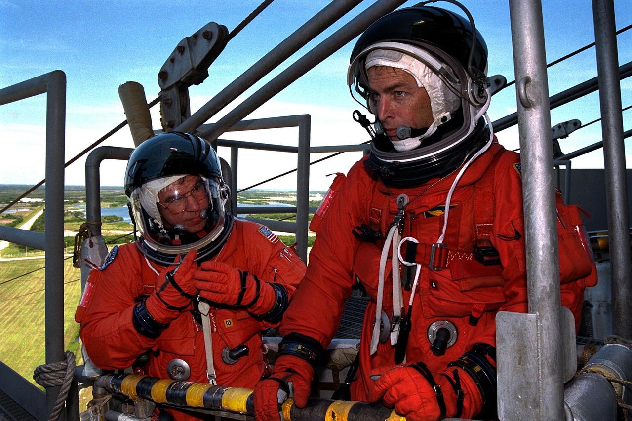 KENNEDY SPACE CENTER, Fla. -- STS-86 Commander James D. Wetherbee, at right, and Pilot Michael J. Bloomfield practice emergency egress procedures in a slidewire basket as part of Terminal Countdown Demonstration Test (TCDT) activities at Launch Pad 39A. STS-86 will be the seventh docking of the Space Shuttle with the Russian Space Station Mir. Liftoff of the Space Shuttle Atlantis on Mission STS-86 is targeted for Sept. 25