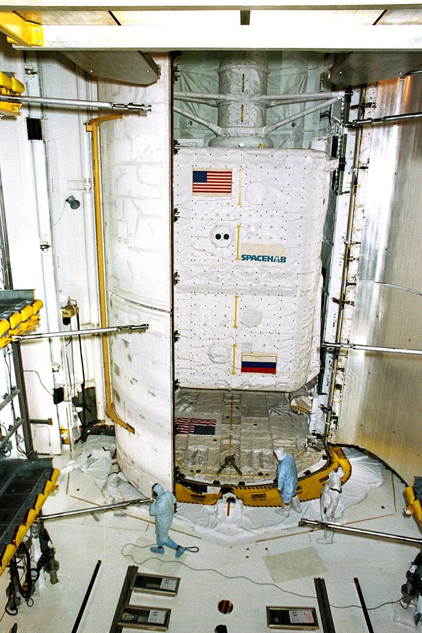 KENNEDY SPACE CENTER, FLA. -- Workers prepare to close the payload bay doors of the Space Shuttle Atlantis in preparation for the planned Sept. 25 liftoff of Mission STS-86. The primary payload is the SPACEHAB Double Module, at center, which will be used mainly as a large pressurized cargo container for the three-and-a-half tons of science/logistical equipment and supplies to be exchanged between Atlantis and the Russian Space Station Mir. STS-86 will be the seventh docking of the Space Shuttle with the Mir. The 10-day flight also is scheduled to include the transfer of the sixth American to live and work aboard the Russian orbiting outpost. Liftoff of Atlantis and its seven-member crew is targeted for 10:34 p.m. EDT from Launch Pad 39A