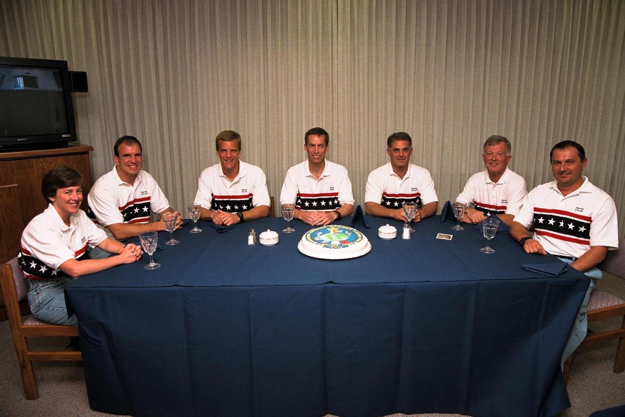 As part of the final STS-86 prelaunch activities, the seven crew members gather for a snack and a photo opportunity in the Operations and Checkout Building. From left are Mission Specialist Wendy B. Lawrence; Pilot Michael J. Bloomfield; Mission Specialist Scott E. Parazynski; Commander James D. Wetherbee; Mission Specialist David A. Wolf; Mission Specialist Jean-Loup J.M. Chretien of the French Space Agency, CNES; and Mission Specialist Vladimir Georgievich Titov of the Russian Space Agency. After a weather briefing, the astronauts will don their orange launch and entry suits and depart for Launch Pad 39A where the Space Shuttle Atlantis awaits liftoff at about 10:34 p.m. EDT, Sept. 25. The exact launch time may vary slightly based on calculations of the Russian Space Station Mir’s precise location in space at the time of liftoff. STS-86 is slated to be the seventh of nine planned dockings of the Shuttle with the Mir. Wolf is scheduled to become a member of the Mir 24 crew, replacing U.S. astronaut C. Michael Foale who will return to Earth aboard Atlantis after more than four months on the Russian orbiting outpost