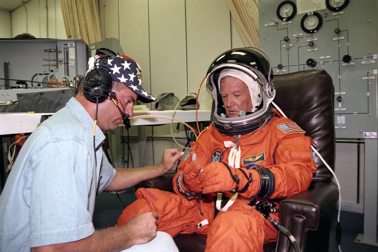 STS-86 Mission Specialist Jean-Loup J.M. Chretien of the French Space Agency, CNES, gets assistance from a suit technician in adjusting his launch and entry suit in the Operations and Checkout Building. This will be Chretien’s third spaceflight, but his first on the Space Shuttle. He and the six other crew members will depart shortly for Launch Pad 39A, where the Space Shuttle Atlantis awaits liftoff on a 10-day mission slated to be the seventh docking of the Shuttle with the Russian Space Station Mir
