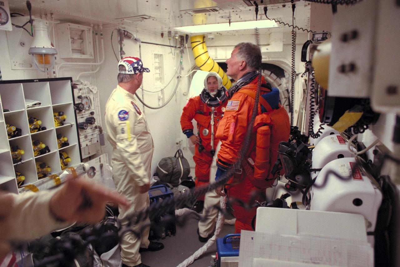 STS-86 Mission Specialists Wendy B. Lawrence, at center facing camera, and Jean-Loup J.M. Chretien of the French Space Agency, CNES, prepare to enter the Space Shuttle Atlantis at Launch Pad 39A, with the assistance of white room closeout crew member Jim Davis, a NASA quality assurance specialist