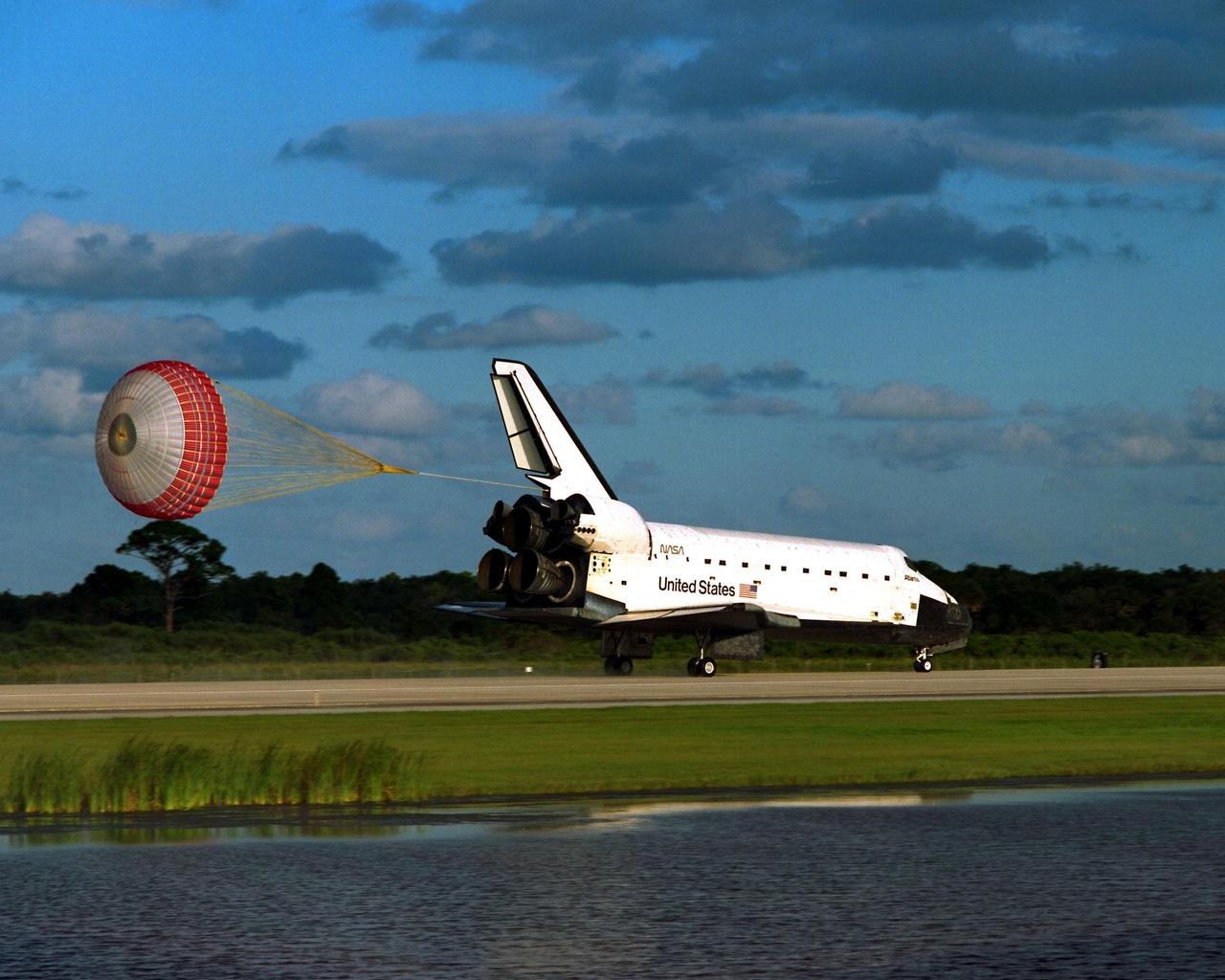 KENNEDY SPACE CENTER, Fla. -- The orbiter drag chute deploys after the Space Shuttle orbiter Atlantis lands on Runway 15 of the KSC Shuttle Landing Facility (SLF) at the conclusion of the nearly 11-day STS-86 mission. Main gear touchdown was at 5:55:09 p.m. EDT, Oct. 6, 1997, with an unofficial mission-elapsed time of 10 days, 19 hours, 20 minutes and 50 seconds. The first two KSC landing opportunities on Sunday were waved off because of weather concerns. The 87th Space Shuttle mission was the 40th landing of the Shuttle at KSC. On Sunday evening, the Space Shuttle program reached a milestone: The total flight time of the Shuttle passed the two-year mark. STS86 was the seventh of nine planned dockings of the Space Shuttle with the Russian Space Station Mir. STS-86 Mission Specialist David A. Wolf replaced NASA astronaut and Mir 24 crew member C. Michael Foale, who has been on the Mir since mid-May. Foale returned to Earth on Atlantis with the remainder of the STS-86 crew. The other crew members are Commander James D. Wetherbee, Pilot Michael J. Bloomfield, and Mission Specialists Wendy B. Lawrence, Scott E. Parazynski, Vladimir Georgievich Titov of the Russian Space Agency, and Jean-Loup J.M. Chretien of the French Space Agency, CNES. Wolf is scheduled to remain on the Mir until the STS-89 Shuttle mission in January. Besides the docking and crew exchange, STS-86 included the transfer of more than three-and-a-half tons of science/logistical equipment and supplies between the two orbiting spacecraft. Parazynski and Titov also conducted a spacewalk while Atlantis and the Mir were docked