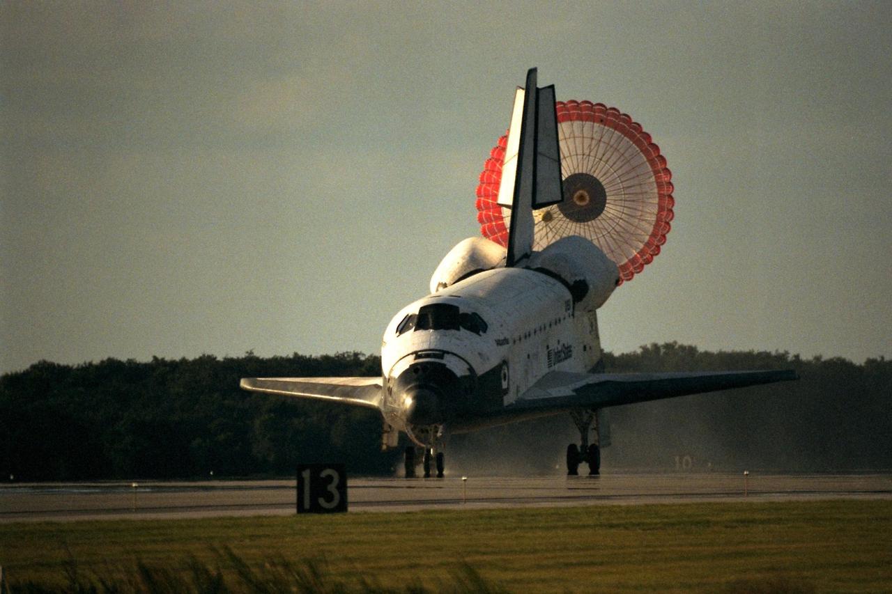 KENNEDY SPACE CENTER, Fla. -- The orbiter drag chute deploys after the Space Shuttle orbiter Atlantis lands on Runway 15 of the KSC Shuttle Landing Facility (SLF) at the conclusion of the nearly 11-day STS-86 mission. Main gear touchdown was at 5:55:09 p.m. EDT, Oct. 6, 1997, with an unofficial mission-elapsed time of 10 days, 19 hours, 20 minutes and 50 seconds. The first two KSC landing opportunities on Sunday were waved off because of weather concerns. The 87th Space Shuttle mission was the 40th landing of the Shuttle at KSC. On Sunday evening, the Space Shuttle program reached a milestone: The total flight time of the Shuttle passed the two-year mark. STS86 was the seventh of nine planned dockings of the Space Shuttle with the Russian Space Station Mir. STS-86 Mission Specialist David A. Wolf replaced NASA astronaut and Mir 24 crew member C. Michael Foale, who has been on the Mir since mid-May. Foale returned to Earth on Atlantis with the remainder of the STS-86 crew. The other crew members are Commander James D. Wetherbee, Pilot Michael J. Bloomfield, and Mission Specialists Wendy B. Lawrence, Scott E. Parazynski, Vladimir Georgievich Titov of the Russian Space Agency, and Jean-Loup J.M. Chretien of the French Space Agency, CNES. Wolf is scheduled to remain on the Mir until the STS-89 Shuttle mission in January. Besides the docking and crew exchange, STS-86 included the transfer of more than three-and-a-half tons of science/logistical equipment and supplies between the two orbiting spacecraft. Parazynski and Titov also conducted a spacewalk while Atlantis and the Mir were docked