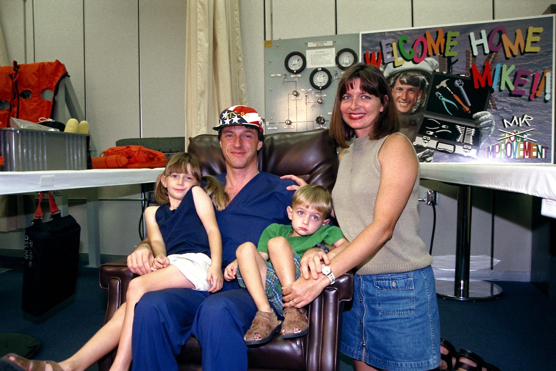 Astronaut C. Michael Foale is reunited with his family after an approximate four-and-a-half-month stay aboard the Russian Space Station Mir. Wife Rhonda, 5-year-old Jenna and 3-year-old Ian stayed up for the late-night homecoming after the Oct. 6 landing of the Space Shuttle orbiter Atlantis on the STS-86 mission. Foale, a member of the Mir 24 crew, was dropped off on the Russian space station during the STS-84 mission in mid-May. He joined the STS-86 crew aboard Atlantis for the return trip to Earth. STS-86 was the seventh docking of the Space Shuttle with the Mir. STS-86 Mission Specialist David A. Wolf replaced Foale on the Russian station