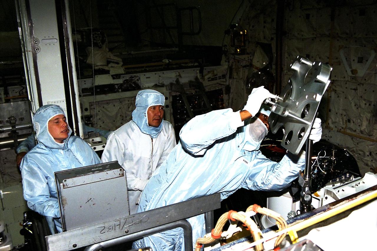 Participating in the Crew Equipment Integration Test (CEIT) at Kennedy Space Center are STS-87 crew members, assisted by Glenda Laws, extravehicular activity (EVA) coordinator, Johnson Space Center, at left. Next to Laws is Mission Specialist Takao Doi, Ph.D., of the National Space Development Agency of Japan, who is looking on as Mission Specialist Winston Scott gets a hands-on look at some of the equipment. The STS-87 mission will be the fourth United States Microgravity Payload and flight of the Spartan-201 deployable satellite. During the mission, scheduled for a Nov. 19 liftoff from KSC, Dr. Doi and Scott will both perform spacewalks