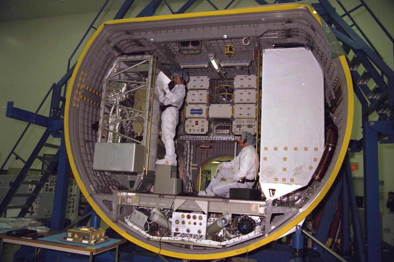 KENNEDY SPACE CENTER, FLA. -- Technicians from the National Space Development Agency of Japan (NASDA) test the real-time radiation monitoring device on SPACEHAB at Kennedy Space Center in preparation for the STS-89 mission, slated to be the first Shuttle launch of 1998. STS-89 will be the eighth of nine scheduled Mir dockings and will include a double module of SPACEHAB, used mainly as a large pressurized cargo container for science, logistical equipment and supplies to be exchanged between the orbiter Endeavour and the Russian Space Station Mir. The nine-day flight of STS-89 also is scheduled to include the transfer of the seventh American to live and work aboard the Russian orbiting outpost. Liftoff of Endeavour and its seven-member crew is targeted for Jan. 15, 1998, at 1:03 a.m. EDT from Launch Pad 39A