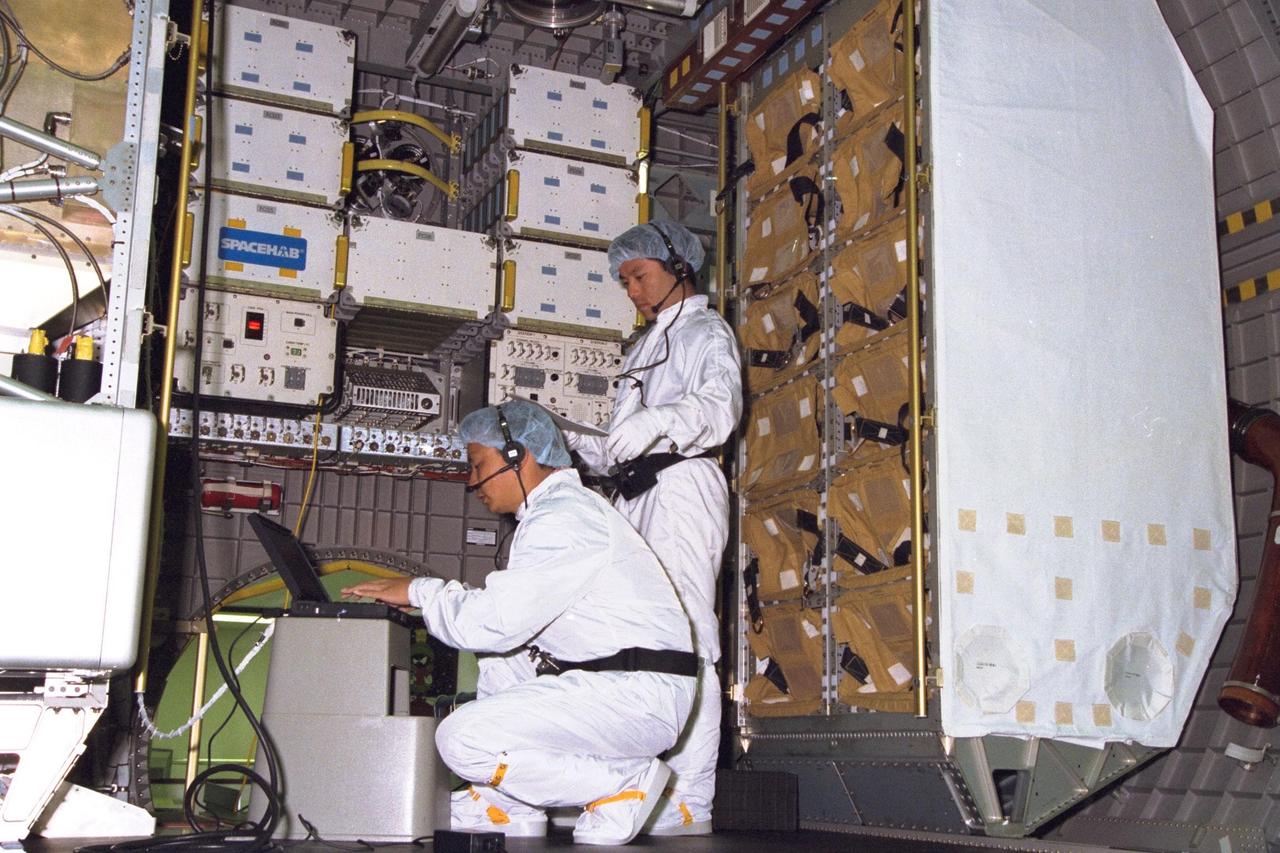 KENNEDY SPACE CENTER, FLA. -- Technicians from the National Space Development Agency of Japan (NASDA) test the real-time radiation monitoring device on SPACEHAB at Kennedy Space Center in preparation for the STS-89 mission, slated to be the first Shuttle launch of 1998. STS-89 will be the eighth of nine scheduled Mir dockings and will include a double module of SPACEHAB, used mainly as a large pressurized cargo container for science, logistical equipment and supplies to be exchanged between the orbiter Endeavour and the Russian Space Station Mir. The nine-day flight of STS-89 also is scheduled to include the transfer of the seventh American to live and work aboard the Russian orbiting outpost. Liftoff of Endeavour and its seven-member crew is targeted for Jan. 15, 1998, at 1:03 a.m. EDT from Launch Pad 39A