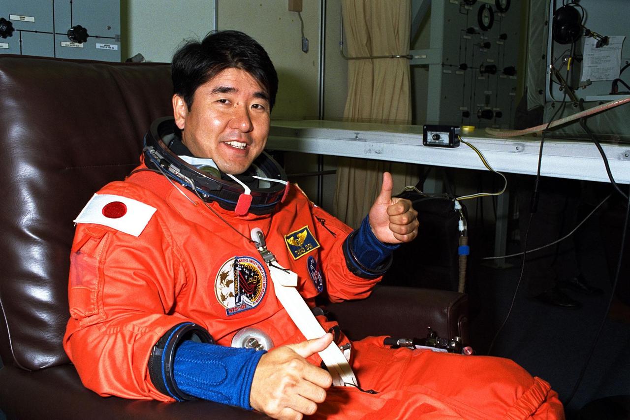 STS-87 Mission Specialist Takao Doi, Ph.D., of the National Space Development Agency of Japan, gives a ‘thumbs up’ in his launch and entry suit in the Operations and Checkout Building. He and the five other crew members will depart shortly for Launch Pad 39B, where the Space Shuttle Columbia awaits liftoff on a 16-day mission to perform microgravity and solar research. Dr. Doi is scheduled to perform an extravehicular activity spacewalk with Mission Specialist Winston Scott during STS-87