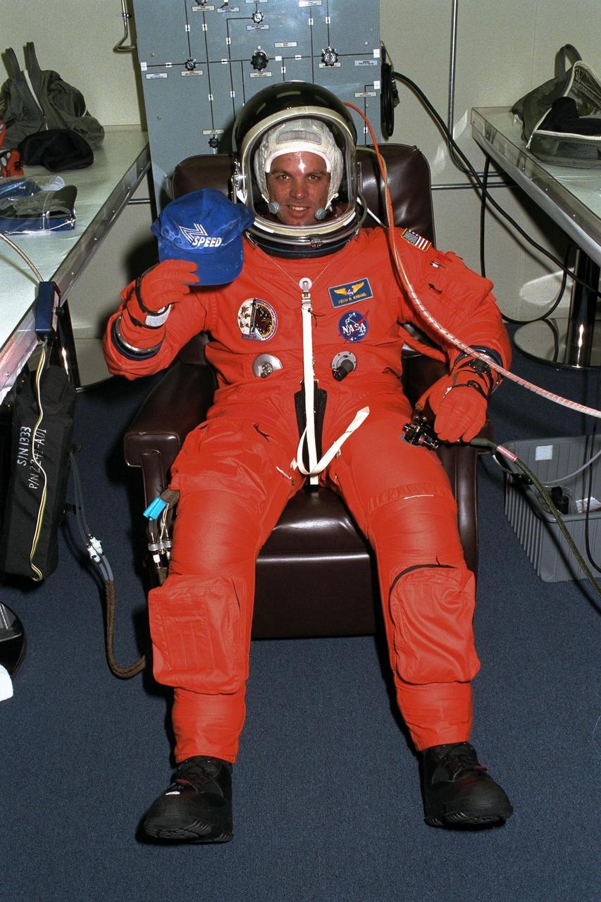 STS-87 Commander Kevin Kregel sits in his launch and entry suit in the Operations and Checkout Building holding a cap of his son’s soccer team of which Kregel is the coach. Shortly, he and the five other crew members of STS-87 will depart for Launch Pad 39B, where the Space Shuttle Columbia awaits liftoff on a 16-day mission to perform microgravity and solar research. A veteran of two space flights (STS-70 and -78), Kregel has logged more than 618 hours in space