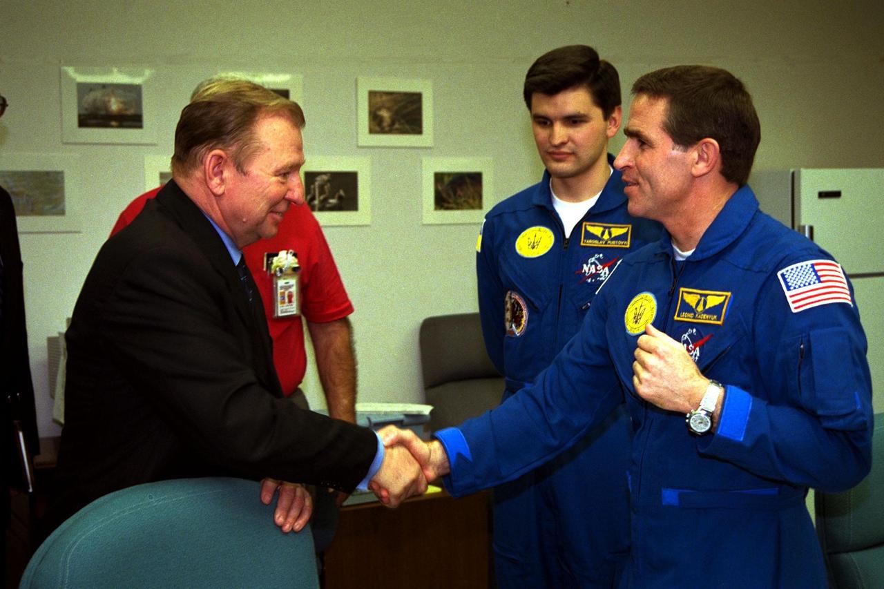The president of the Ukraine, Leonid Kuchma, shakes hands with Payload Specialist Leonid Kadenyuk, at right, as backup Payload Specialist Yaroslav Pustovyi, both of the National Space Agency of Ukraine, looks on during prelaunch activities leading up to the scheduled Nov. 19 launch of STS-87. STS-87 will be the fourth flight of the United States Microgravity Payload and the Spartan-201 deployable satellite. During the mission, Kadenyuk will pollinate Brassica rapa plants as part of the Collaborative Ukrainian Experiment, or CUE, aboard Columbia during its 16-day mission. The CUE experiment is a collection of 10 plant space biology experiments that will fly in Columbia's middeck and will feature an educational component that involves evaluating the effects of microgravity on Brassica rapa seedlings. Students in Ukrainian and American schools will participate in the same experiment with Kadenyuk in space. Kadenyuk will be flying his first Shuttle mission on STS-87