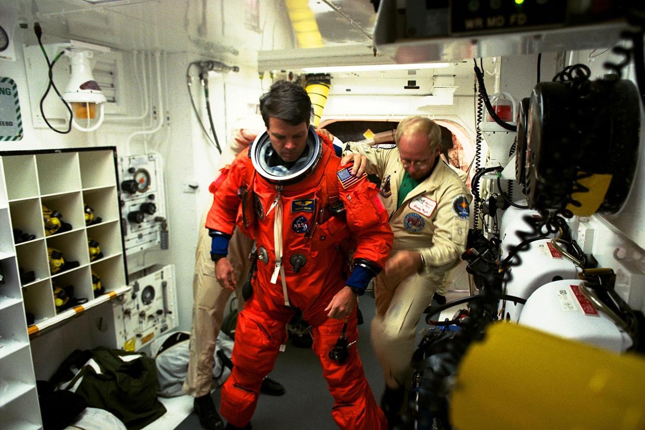 STS-87 Commander Kevin Kregel is assisted with his ascent and re-entry flight suit in the white room at Launch Pad 39B by Danny Wyatt, NASA quality assurance specialist. STS-87 is the fourth flight of the United States Microgravity Payload and Spartan-201. A veteran of two space flights (STS-70 and -78), Kregel has logged more than 618 hours in space