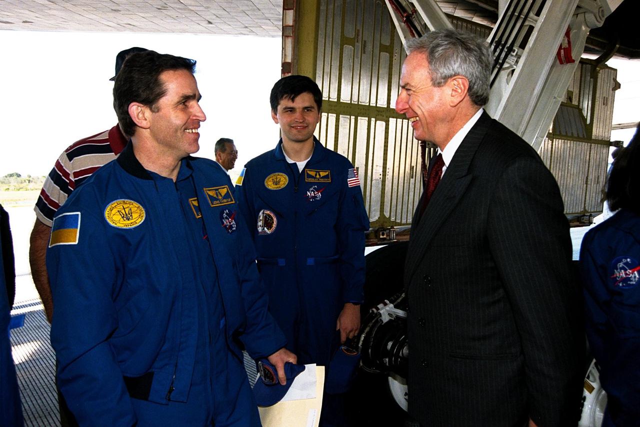 STS-87 Payload Specialist Leonid Kadenyuk of the National Space Agency of Ukraine (NSAU), at left, greets NASA Administrator Daniel Goldin, at right, as back-up Payload Specialist Yaroslav Pustovyi, also of NSAU, looks on. STS-87 concluded its mission with a main gear touchdown at 7:20:04 a.m. EST Dec. 5, at KSC's Shuttle Landing Facility Runway 33, drawing the 15-day, 16-hour and 34-minute-long mission of 6.5 million miles to a close. Also onboard the orbiter were Commander Kevin Kregel; Pilot Steven Lindsey; and Mission Specialists Winston Scott; Kalpana Chawla, Ph.D.; and Takao Doi, Ph.D. of the National Space Development Agency of Japan. During the 88th Space Shuttle mission, the crew performed experiments on the United States Microgravity Payload-4 and pollinated plants as part of the Collaborative Ukrainian Experiment. This was the 12th landing for Columbia at KSC and the 41st KSC landing in the history of the Space Shuttle program