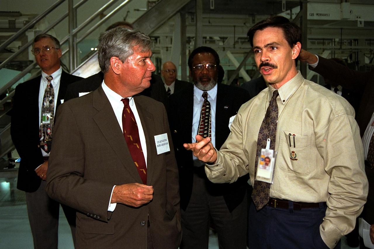 United States Senator Bob Graham of Florida (left) visits the Space Station Processing Facility at Kennedy Space Center (KSC) and is briefed on hardware processing for the International Space Station by Jon Cowart, Flight 2A Manager, NASA Space Station Hardware Integration Office. Jim Jennings, Deputy Director of KSC, is shown in the background, center, observing the briefing