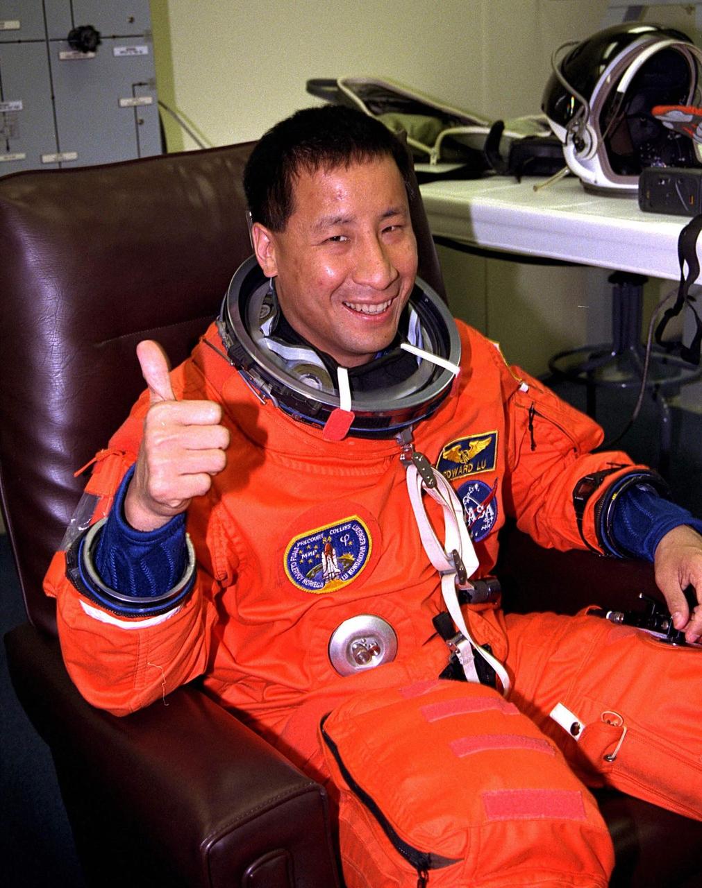 STS-84 Mission Specialist Edward Tsang Lu gives a "thumbs up" as he dons his launch and entry suit during final prelaunch preparations in the Operations and Checkout Building. This will be Lu’s first space flight. Lu and six other crew members will depart shortly for Launch Pad 39A, where the Space Shuttle Atlantis awaits liftoff on a mission to dock with the Russian Space Station Mir