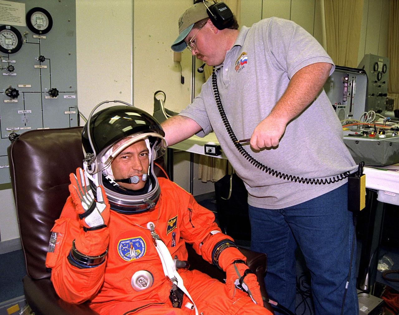 STS-84 Mission Specialist Carlos I. Noriega gets assistance from a suit technician as he dons his launch and entry suit during final prelaunch preparations in the Operations and Checkout Building. This will be Noriega’s first space flight. Noriega and six other crew members will depart shortly for Launch Pad 39A, where the Space Shuttle Atlantis awaits liftoff on a mission to dock with the Russian Space Station Mir