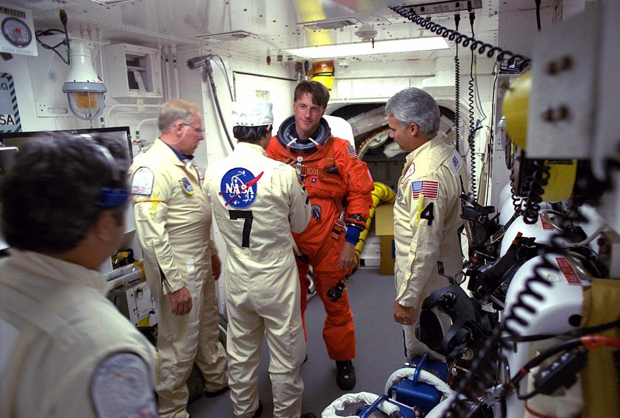 STS-84 Mission Specialist C. Michael Foale prepares to enter the Space Shuttle Atlantis at Launch Pad 39A with help from white room closeout crew members. The fourth Shuttle mission of 1997 will be the sixth docking of the Space Shuttle with the Russian Space Station Mir. The commander is Charles J. Precourt. The pilot is Eileen Marie Collins. The five mission specialists are C. Michael Foale, Carlos I. Noriega, Edward Tsang Lu, Jean-Francois Clervoy of the European Space Agency and Elena V. Kondakova of the Russian Space Agency. The planned nine-day mission will include the exchange of Foale for U.S. astronaut and Mir 23 crew member Jerry M. Linenger, who has been on Mir since Jan. 15. Linenger transferred to Mir during the last docking mission, STS-81; he will return to Earth on Atlantis. Foale is slated to remain on Mir for about four months until he is replaced in September by STS-86 Mission Specialist Wendy B. Lawrence. During the five days Atlantis is scheduled to be docked with the Mir, the STS-84 crew and the Mir 23 crew, including two Russian cosmonauts, Commander Vasily Tsibliev and Flight Engineer Alexander Lazutkin, will participate in joint experiments. The STS-84 mission also will involve the transfer of more than 7,300 pounds of water, logistics and science equipment to and from the Mir. Atlantis is carrying a nearly 300-pound oxygen generator to replace one of two Mir units which have experienced malfunctions. The oxygen it generates is used for breathing by the Mir crew