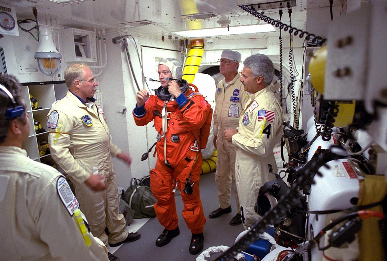 STS-84 Commander Charles J. Precourt prepares to enter the Space Shuttle Atlantis at Launch Pad 39A with help from white room closeout crew members. The fourth Shuttle mission of 1997 will be the sixth docking of the Space Shuttle with the Russian Space Station Mir. The commander is Charles J. Precourt. The pilot is Eileen Marie Collins. The five mission specialists are C. Michael Foale, Carlos I. Noriega, Edward Tsang Lu, Jean-Francois Clervoy of the European Space Agency and Elena V. Kondakova of the Russian Space Agency. The planned nine-day mission will include the exchange of Foale for U.S. astronaut and Mir 23 crew member Jerry M. Linenger, who has been on Mir since Jan. 15. Linenger transferred to Mir during the last docking mission, STS-81; he will return to Earth on Atlantis. Foale is slated to remain on Mir for about four months until he is replaced in September by STS-86 Mission Specialist Wendy B. Lawrence. During the five days Atlantis is scheduled to be docked with the Mir, the STS-84 crew and the Mir 23 crew, including two Russian cosmonauts, Commander Vasily Tsibliev and Flight Engineer Alexander Lazutkin, will participate in joint experiments. The STS-84 mission also will involve the transfer of more than 7,300 pounds of water, logistics and science equipment to and from the Mir. Atlantis is carrying a nearly 300-pound oxygen generator to replace one of two Mir units which have experienced malfunctions. The oxygen it generates is used for breathing by the Mir crew