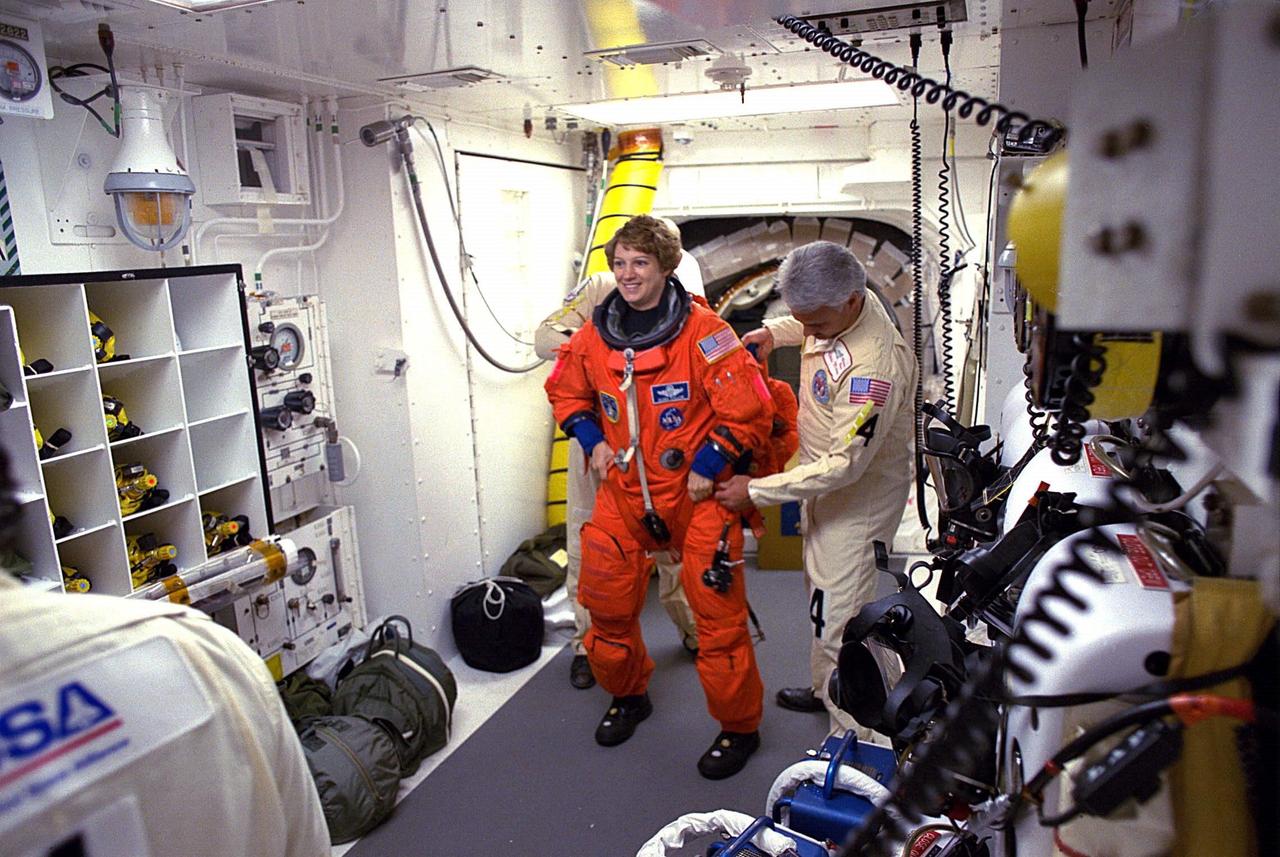STS-84 Pilot Eileen M. Collins prepares to enter the Space Shuttle Atlantis at Launch Pad 39A with help from white room closeout crew members. The fourth Shuttle mission of 1997 will be the sixth docking of the Space Shuttle with the Russian Space Station Mir. The commander is Charles J. Precourt. The pilot is Eileen Marie Collins. The five mission specialists are C. Michael Foale, Carlos I. Noriega, Edward Tsang Lu, Jean-Francois Clervoy of the European Space Agency and Elena V. Kondakova of the Russian Space Agency. The planned nine-day mission will include the exchange of Foale for U.S. astronaut and Mir 23 crew member Jerry M. Linenger, who has been on Mir since Jan. 15. Linenger transferred to Mir during the last docking mission, STS-81; he will return to Earth on Atlantis. Foale is slated to remain on Mir for about four months until he is replaced in September by STS-86 Mission Specialist Wendy B. Lawrence. During the five days Atlantis is scheduled to be docked with the Mir, the STS-84 crew and the Mir 23 crew, including two Russian cosmonauts, Commander Vasily Tsibliev and Flight Engineer Alexander Lazutkin, will participate in joint experiments. The STS-84 mission also will involve the transfer of more than 7,300 pounds of water, logistics and science equipment to and from the Mir. Atlantis is carrying a nearly 300-pound oxygen generator to replace one of two Mir units which have experienced malfunctions. The oxygen it generates is used for breathing by the Mir crew