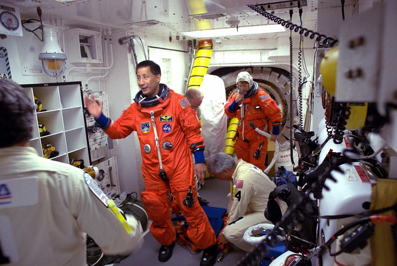STS-84 Mission Specialist Edward T. Lu prepares to enter the Space Shuttle Atlantis at Launch Pad 39A with help from white room closeout crew members. The fourth Shuttle mission of 1997 will be the sixth docking of the Space Shuttle with the Russian Space Station Mir. The commander is Charles J. Precourt. The pilot is Eileen Marie Collins. The five mission specialists are C. Michael Foale, Carlos I. Noriega, Edward Tsang Lu, Jean-Francois Clervoy of the European Space Agency and Elena V. Kondakova of the Russian Space Agency. The planned nine-day mission will include the exchange of Foale for U.S. astronaut and Mir 23 crew member Jerry M. Linenger, who has been on Mir since Jan. 15. Linenger transferred to Mir during the last docking mission, STS-81; he will return to Earth on Atlantis. Foale is slated to remain on Mir for about four months until he is replaced in September by STS-86 Mission Specialist Wendy B. Lawrence. During the five days Atlantis is scheduled to be docked with the Mir, the STS-84 crew and the Mir 23 crew, including two Russian cosmonauts, Commander Vasily Tsibliev and Flight Engineer Alexander Lazutkin, will participate in joint experiments. The STS-84 mission also will involve the transfer of more than 7,300 pounds of water, logistics and science equipment to and from the Mir. Atlantis is carrying a nearly 300-pound oxygen generator to replace one of two Mir units which have experienced malfunctions. The oxygen it generates is used for breathing by the Mir crew