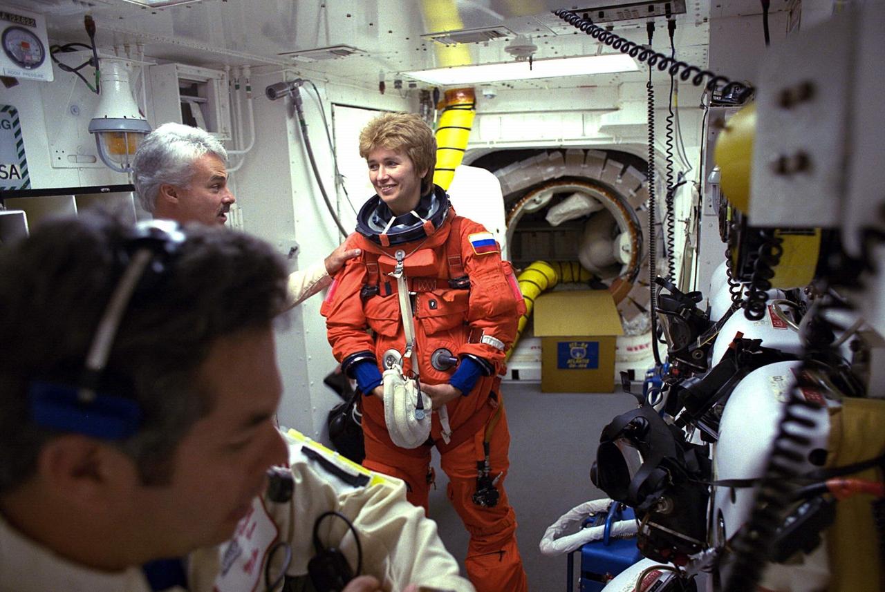 STS-84 Mission Specialist Elena V. Kondakova prepares to enter the Space Shuttle Atlantis at Launch Pad 39A with help from white room closeout crew members. The fourth Shuttle mission of 1997 will be the sixth docking of the Space Shuttle with the Russian Space Station Mir. The commander is Charles J. Precourt. The pilot is Eileen Marie Collins. The five mission specialists are C. Michael Foale, Carlos I. Noriega, Edward Tsang Lu, Jean-Francois Clervoy of the European Space Agency and Elena V. Kondakova of the Russian Space Agency. The planned nine-day mission will include the exchange of Foale for U.S. astronaut and Mir 23 crew member Jerry M. Linenger, who has been on Mir since Jan. 15. Linenger transferred to Mir during the last docking mission, STS-81; he will return to Earth on Atlantis. Foale is slated to remain on Mir for about four months until he is replaced in September by STS-86 Mission Specialist Wendy B. Lawrence. During the five days Atlantis is scheduled to be docked with the Mir, the STS-84 crew and the Mir 23 crew, including two Russian cosmonauts, Commander Vasily Tsibliev and Flight Engineer Alexander Lazutkin, will participate in joint experiments. The STS-84 mission also will involve the transfer of more than 7,300 pounds of water, logistics and science equipment to and from the Mir. Atlantis is carrying a nearly 300-pound oxygen generator to replace one of two Mir units which have experienced malfunctions. The oxygen it generates is used for breathing by the Mir crew