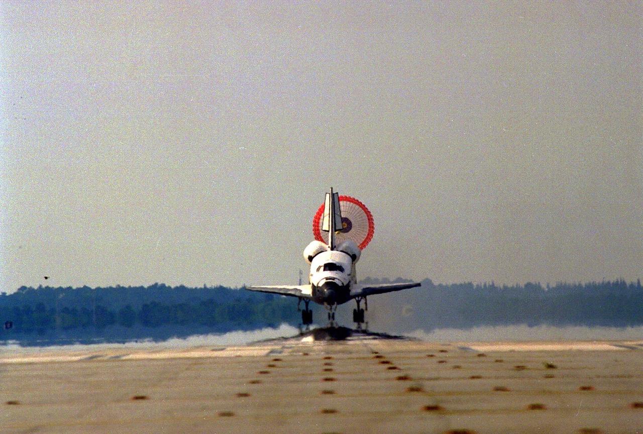The orbiter drag chute deploys after Atlantis touches down on Runway 33 of KSC’s Shuttle Landing Facility at the conclusion of the nine-day STS-84 mission. Main gear touchdown was at 9:27:44 EDT on May 24, 1997. The first landing opportunity was waved off because of low cloud cover. It was the 37th landing at KSC since the Shuttle program began in 1981, and the eighth consecutive landing at KSC. STS-84 was the sixth of nine planned dockings of the Space Shuttle with the Russian Space Station Mir. Atlantis was docked with the Mir for five days. STS-84 Mission Specialist C. Michael Foale replaced astronaut and Mir 23 crew member Jerry M. Linenger, who has been on the Russian space station since Jan. 15. Linenger returned to Earth on Atlantis with the rest of the STS-84 crew, Mission Commander Charles J. Precourt, Pilot Eileen Marie Collins, and Mission Specialists Carlos I. Noriega, Edward Tsang Lu, Elena V. Kondakova of the Russian Space Agency and JeanFrancois Clervoy of the European Space Agency. Foale is scheduled to remain on the Mir for approximately four months, until he is replaced by STS-86 crew member Wendy B. Lawrence in September. Besides the docking and crew exchange, STS-84 included the transfer of more than 7,300 pounds of water, logistics and science experiments and hardware to and from the Mir. Scientific experiments conducted during the STS-84 mission, and scheduled for Foale’s stay on the Mir, are in the fields of advanced technology, Earth sciences, fundamental biology, human life sciences, International Space Station risk mitigation, microgravity sciences and space sciences