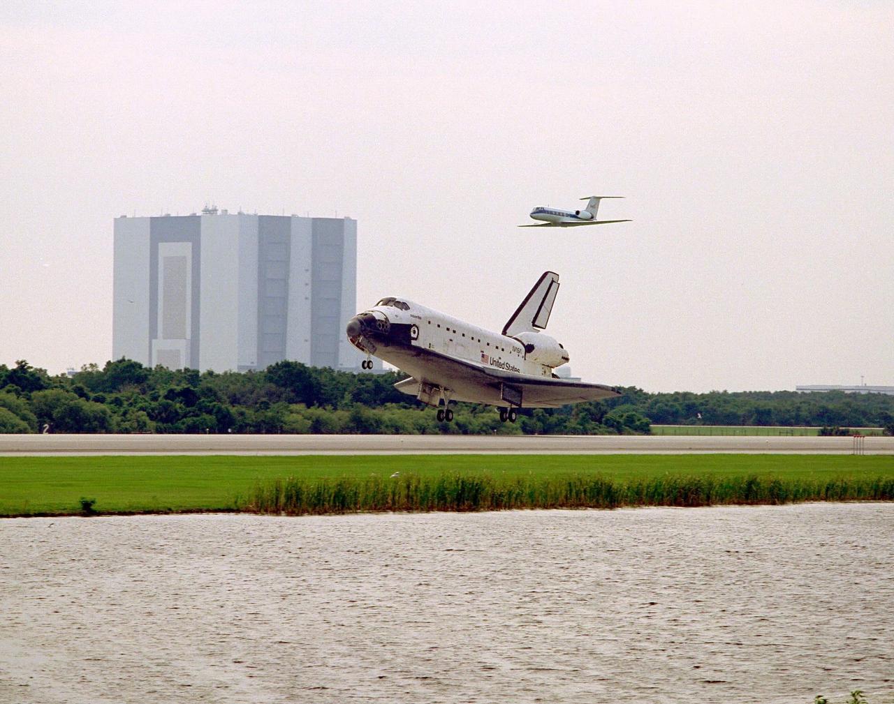 The Space Shuttle orbiter Atlantis rolls out on Runway 33 of KSC’s Shuttle Landing Facility at the conclusion of the nine-day STS-84 mission. The Shuttle Training Aircraft piloted by astronaut Kenneth D. Cockrell, acting deputy chief of the Astronaut Office, is flying above Atlantis. The Vehicle Assembly Building is at left. Main gear touchdown was at 9:27:44 EDT on May 24, 1997. The first landing opportunity was waved off because of low cloud cover. It was the 37th landing at KSC since the Shuttle program began in 1981, and the eighth consecutive landing at KSC. STS-84 was the sixth of nine planned dockings of the Space Shuttle with the Russian Space Station Mir. Atlantis was docked with the Mir for five days. STS-84 Mission Specialist C. Michael Foale replaced astronaut and Mir 23 crew member Jerry M. Linenger, who has been on the Russian space station since Jan. 15. Linenger returned to Earth on Atlantis with the rest of the STS-84 crew, Mission Commander Charles J. Precourt, Pilot Eileen Marie Collins, and Mission Specialists Carlos I. Noriega, Edward Tsang Lu, Elena V. Kondakova of the Russian Space Agency and JeanFrancois Clervoy of the European Space Agency. Foale is scheduled to remain on the Mir for approximately four months, until he is replaced by STS-86 crew member Wendy B. Lawrence in September. Besides the docking and crew exchange, STS-84 included the transfer of more than 7,300 pounds of water, logistics and science experiments and hardware to and from the Mir. Scientific experiments conducted during the STS-84 mission, and scheduled for Foale’s stay on the Mir, are in the fields of advanced technology, Earth sciences, fundamental biology, human life sciences, International Space Station risk mitigation, microgravity sciences and space sciences