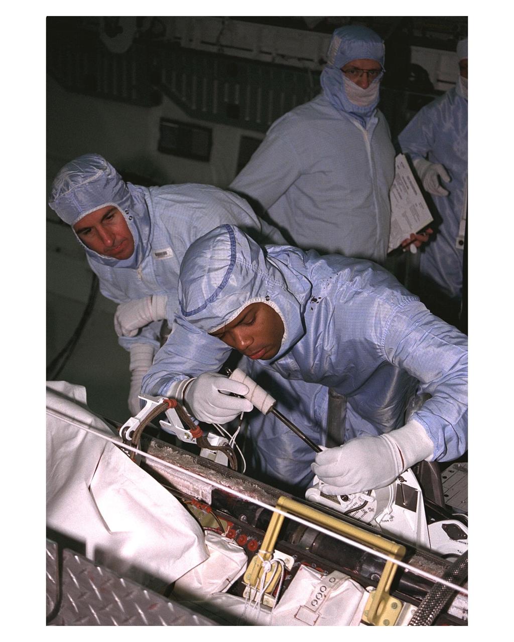 KENNEDY SPACE CENTER, FLA. -- Members of the STS-85 flight crew perform a sharp-edge inspection in the payload bay of the Space Shuttle Orbiter Discovery in the space plane's payload bay during Crew Equipment Interface Test (CEIT) activities for that mission.  They are (from left, foreground) Mission Specialists Stephen K. Robinson and Robert L. Curbeam Jr. (right).  They are accompanied by a United Space Alliance (USA) payload technician.  The Manipulator Flight Demonstration (MFD) payload is one of several that will fly on the STS-85 mission.  This payload is designed to test the operational capability of the Japanese Experiment Module Remote Manipulator System (JEM RMS) Small Fine Arm (SFA).  The arm, which will be a part of the JEM element of the Interntional Space Station, will be operated from the orbiter's aft flight deck during the 11-day mission.  Other payloads that will be aboard Discovery on this space flight include the Cryogenic Infrared Spectrometers and Telescopes for the Atmosphere-Shuttle Pallet Satellite-2 (CRISTA-SPAS-2) Technology Applications and Science-1 (TAS-1) and International Extreme Ultraviolet Hitchhhiker (IEH-2) experiments.