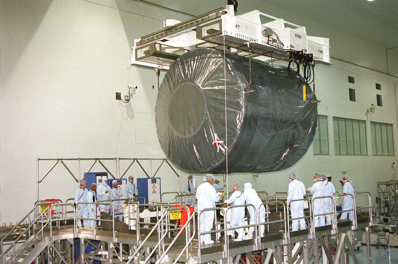 Covered in a protective sheath, International Space Station Node 1 is hoisted for installation in its work stand in the Space Station Processing Facility. The module is the first element of the International Space Station to be manufactured in the United States and the first scheduled to be launched on the Space Shuttle. The Node 1 is currently scheduled to lift off aboard the Space Shuttle Endeavour in July 1998, along with Pressurized Mating Adapters (PMAs) 1 and 2. The 18-foot-in-diameter, 22-foot-long aluminum module was manufactured by the Boeing Co. at Marshall Space Flight Center. Once in space, the Node 1 will function as a connecting passageway to the living and working areas of the International Space Station. It has six hatches that will serve as docking ports to the U.S. laboratory module, U.S. habitation module, an airlock and other space station elements