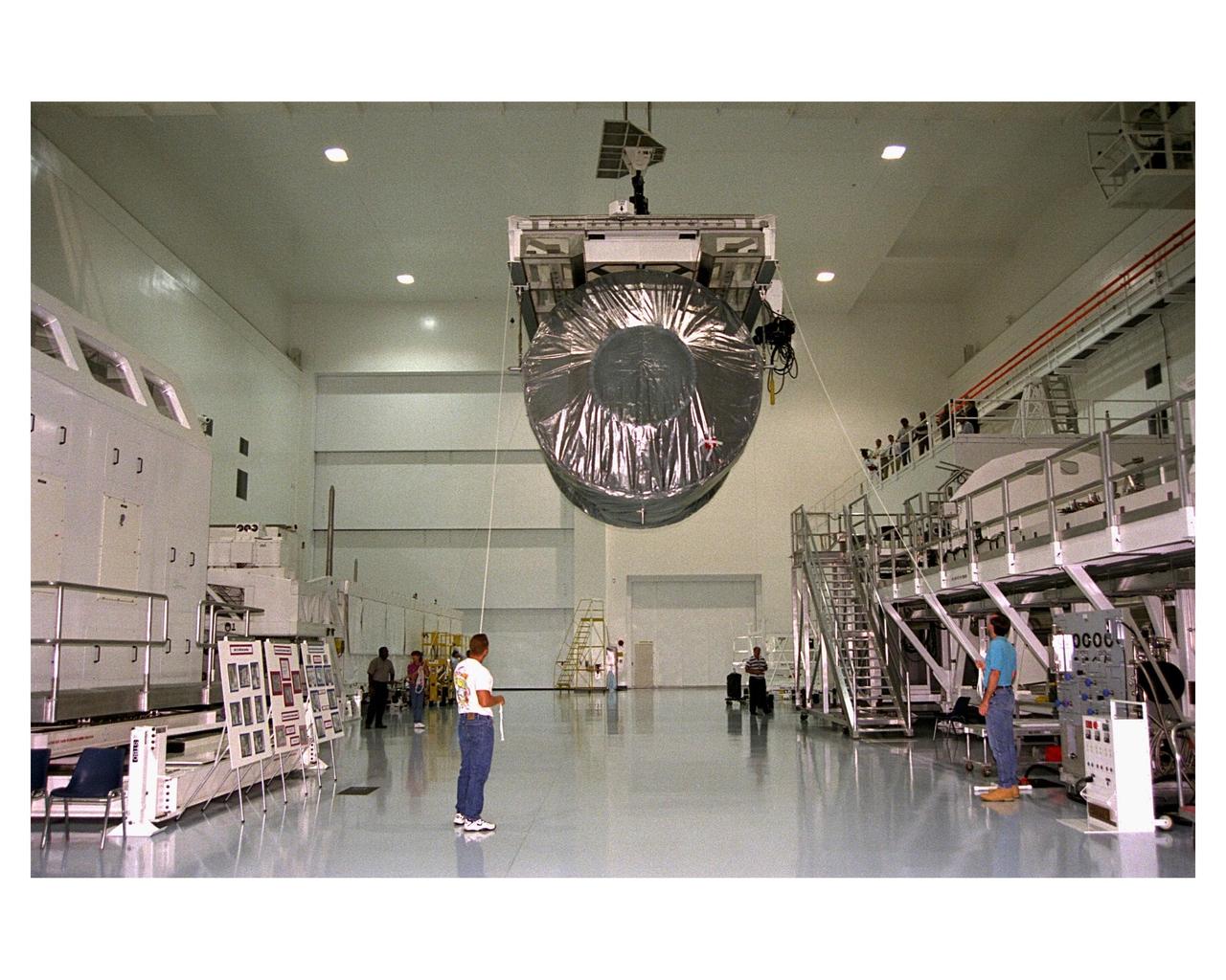 Covered in a protective sheath, International Space Station Node 1 is hoisted for installation in its work stand in the Space Station Processing Facility. The module is the first element of the International Space Station to be manufactured in the United States and the first scheduled to be launched on the Space Shuttle. The Node 1 is currently scheduled to lift off aboard the Space Shuttle Endeavour in July 1998, along with Pressurized Mating Adapters (PMAs) 1 and 2. The 18-foot-in-diameter, 22-foot-long aluminum module was manufactured by the Boeing Co. at Marshall Space Flight Center. Once in space, the Node 1 will function as a connecting passageway to the living and working areas of the International Space Station. It has six hatches that will serve as docking ports to the U.S. laboratory module, U.S. habitation module, an airlock and other space station