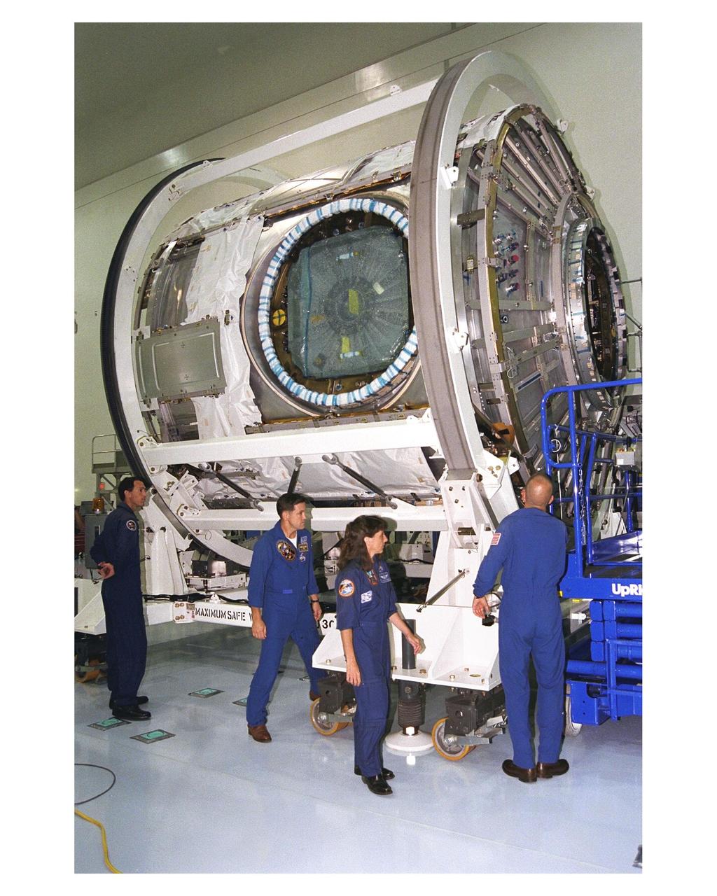 Members of the STS-88 crew examine the Node 1 of the International Space Station in the high bay of the Space Station Processing Facility. The module is the first element of the ISS to be manufactured in the United States and the first scheduled to be launched on the Space Shuttle. The Node 1 is currently scheduled to lift off aboard the Space Shuttle Endeavour in July 1998, along with Pressurized Mating Adapters (PMAs) 1 and 2. The 18-foot-in-diameter, 22-foot-long aluminum module was manufactured by the Boeing Co. at Marshall Space Flight Center. Once in space, the Node 1 will function as a connecting passageway to the living and working areas of the ISS. The six hatches on the Node 1 will serve as docking ports to the U.S. laboratory module, U.S. habitation module, an airlock and other Space Station elements