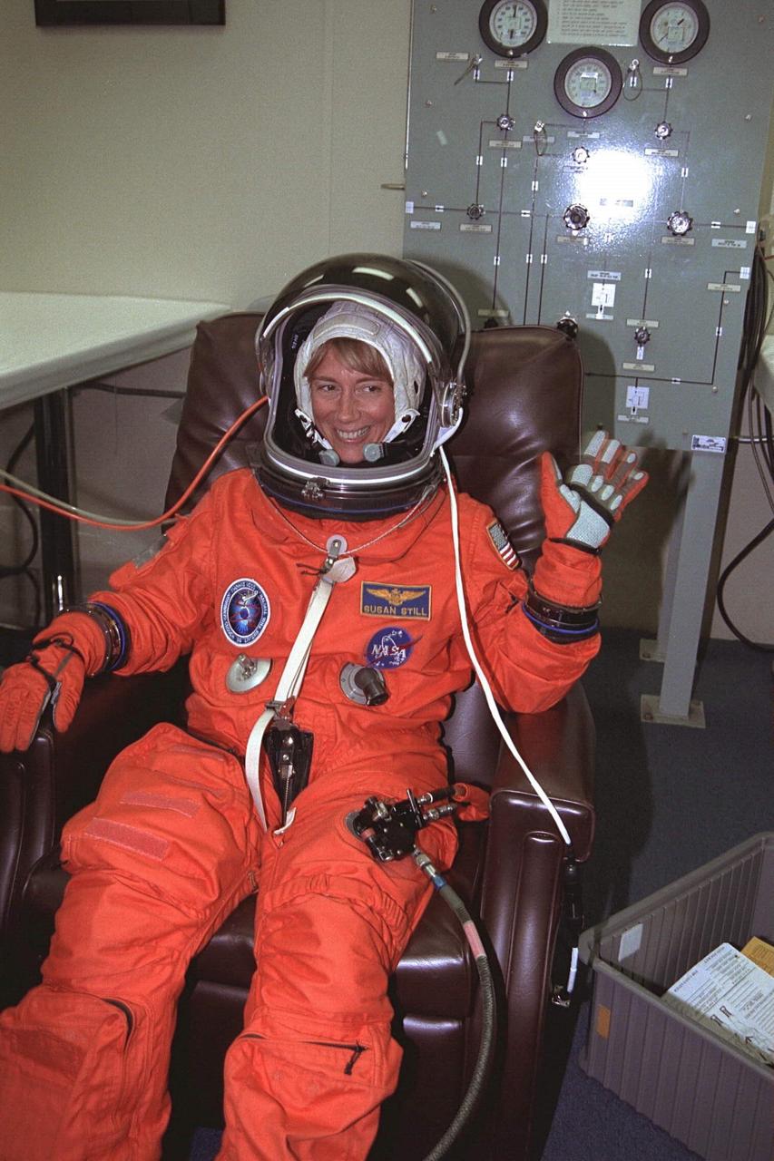 STS-94 Pilot Susan L. Still waves as she  is  assisted into her launch/entry suit in the Operations and Checkout (O&C) Building. She is  the second woman to fly in this capacity on a Space Shuttle. Still is a lieutenant colonel in  the Navy and has more than 2,000 flight hours in 30 different types of aircraft. She also  holds a master’s degree in aerospace engineering. Still will assist Halsell with all phases  of the space flight and will have primary responsibility to take action in the event of an  emergency. After Columbia reaches orbit, Still will be busy with the many and varied  tasks associated with monitoring and maintaining the orbiter. She and six fellow crew  members will shortly depart  the O&C and head for Launch Pad 39A, where the  Space  Shuttle Columbia will lift off during a launch window that opens at 1:50 p.m. EDT, July  1. The launch window was opened 47 minutes early to improve the opportunity to lift off  before Florida summer rain showers reached the space center