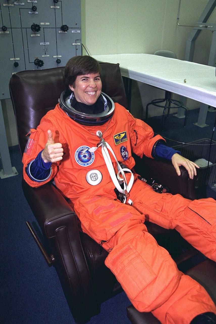 STS-94 Payload Commander Janice Voss smiles  and gives a thumbs-up as she is assisted into her launch/entry suit in the Operations and  Checkout (O&C) Building. She has flown on STS-83, STS-63 and STS-57. Voss holds a  doctorate degree in aeronautics/astronautics from the Massachusetts Institute of  Technology and has earned two NASA Space Flight Medals. As Payload Commander and  a member of the Blue team, Voss will have overall responsibility for the operation of  all  of the  MSL-1  experiments. During the experimentation phase of the mission, she be  working primarily with three combustion experiments. She and six fellow crew members  will shortly depart the O&C and head for Launch Pad 39A, where the  Space Shuttle  Columbia will lift off  during a launch window that opens at 1:50 p.m. EDT,  July 1. The launch window was opened 47 minutes early to improve the opportunity to  lift off before Florida summer rain showers reached the space center