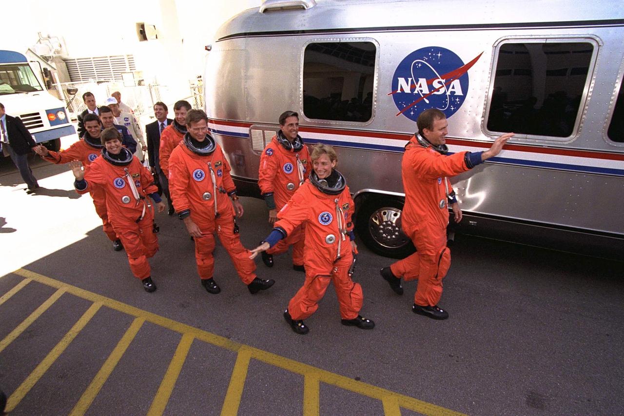The STS-94 crew walks out of the Operations  and Checkout Building and heads for the Astrovan that will transport them to Launch Pad  39A as KSC employees show their support. Waving to the crowd and leading the way are   Mission Commander James D. Halsell, Jr. and Pilot Susan L. Still. Behind Still is  Mission Specialist Donald A.Thomas, followed by Mission Specialist Michael L.  Gernhardt , Payload Commander Janice Voss, and Payload Specialists Roger K.Crouch  and Gregory T. Linteris. During the scheduled 16-day Microgravity Science Laboratory-1  (MSL-1) mission, the Spacelab module will be used to test some of the hardware,  facilities and procedures that are planned for use on the International Space Station while  the flight crew conducts combustion, protein crystal growth and materials processing  experiments. Also onboard is the Hitchhiker Cryogenic Flexible Diode (CRYOFD)  experiment payload, which is attached to the right side of Columbia’s payload bay.The  Space Shuttle Columbia is scheduled to lift off when the launch window opens at 1:50  p.m. EDT, July 1. The launch window was opened 47 minutes early to improve the  opportunity to lift off before Florida summer rain showers reached the space center